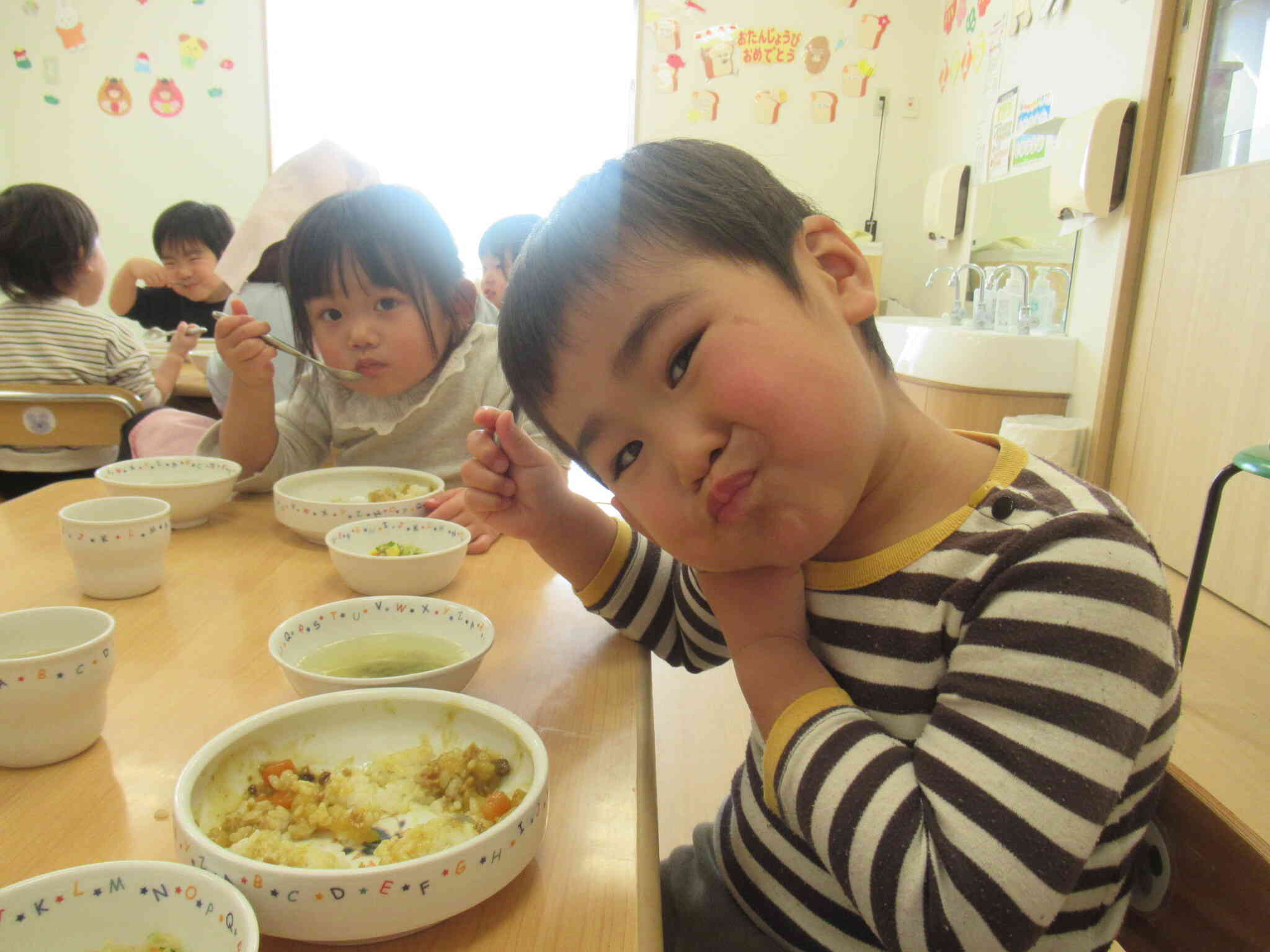 「せんせー！」こっちにも来て。給食、美味しい♪