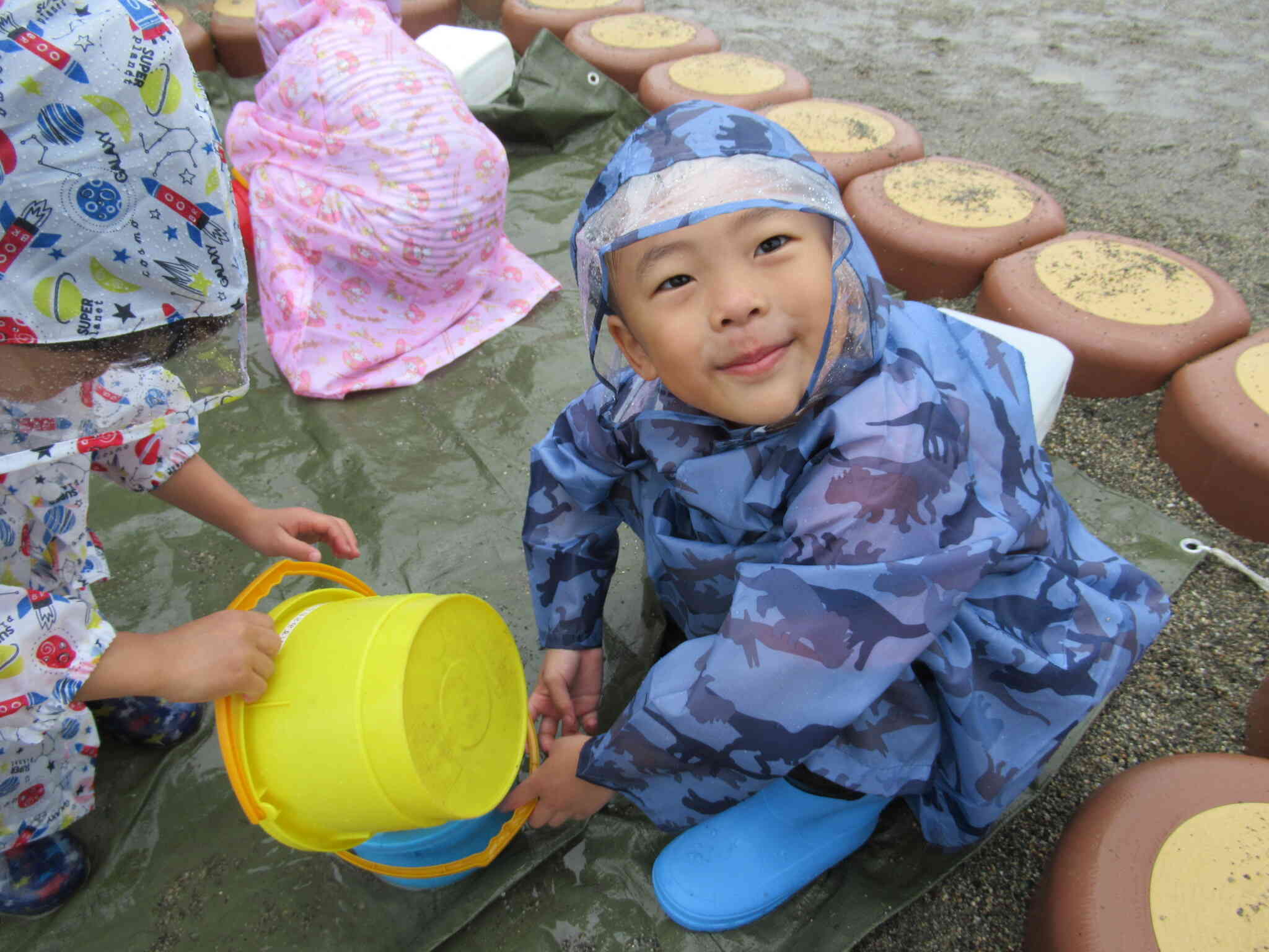 雨降りだけど、園庭で遊んだよ！カッパ着て水たまりで雨をい～っぱい集めたよ！たのしぃ～～っ！
