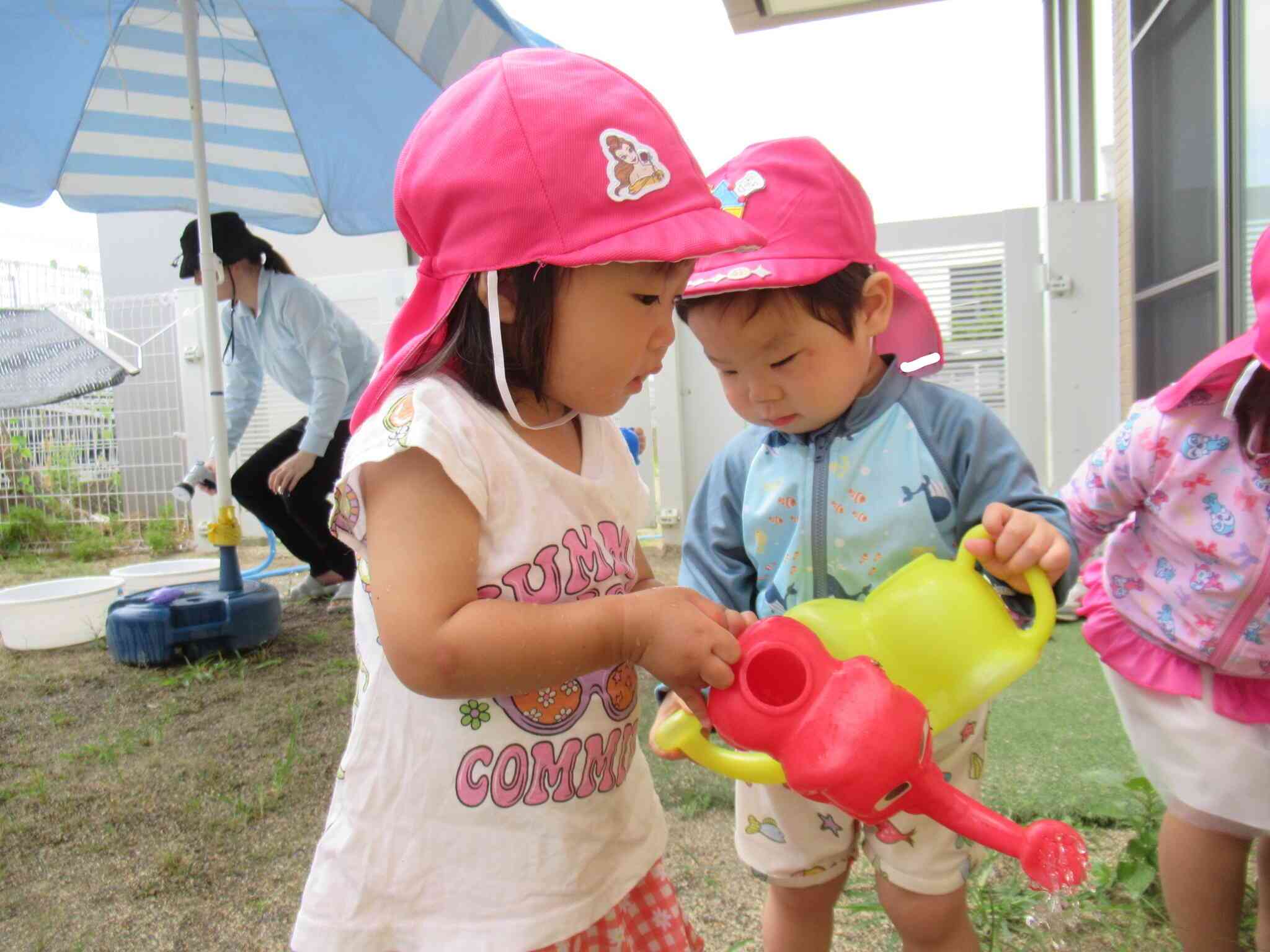 あひる組（1歳児）さん、お水遊びしながら、サツマイモにもお水をたっぷり！おおきくなってね～！