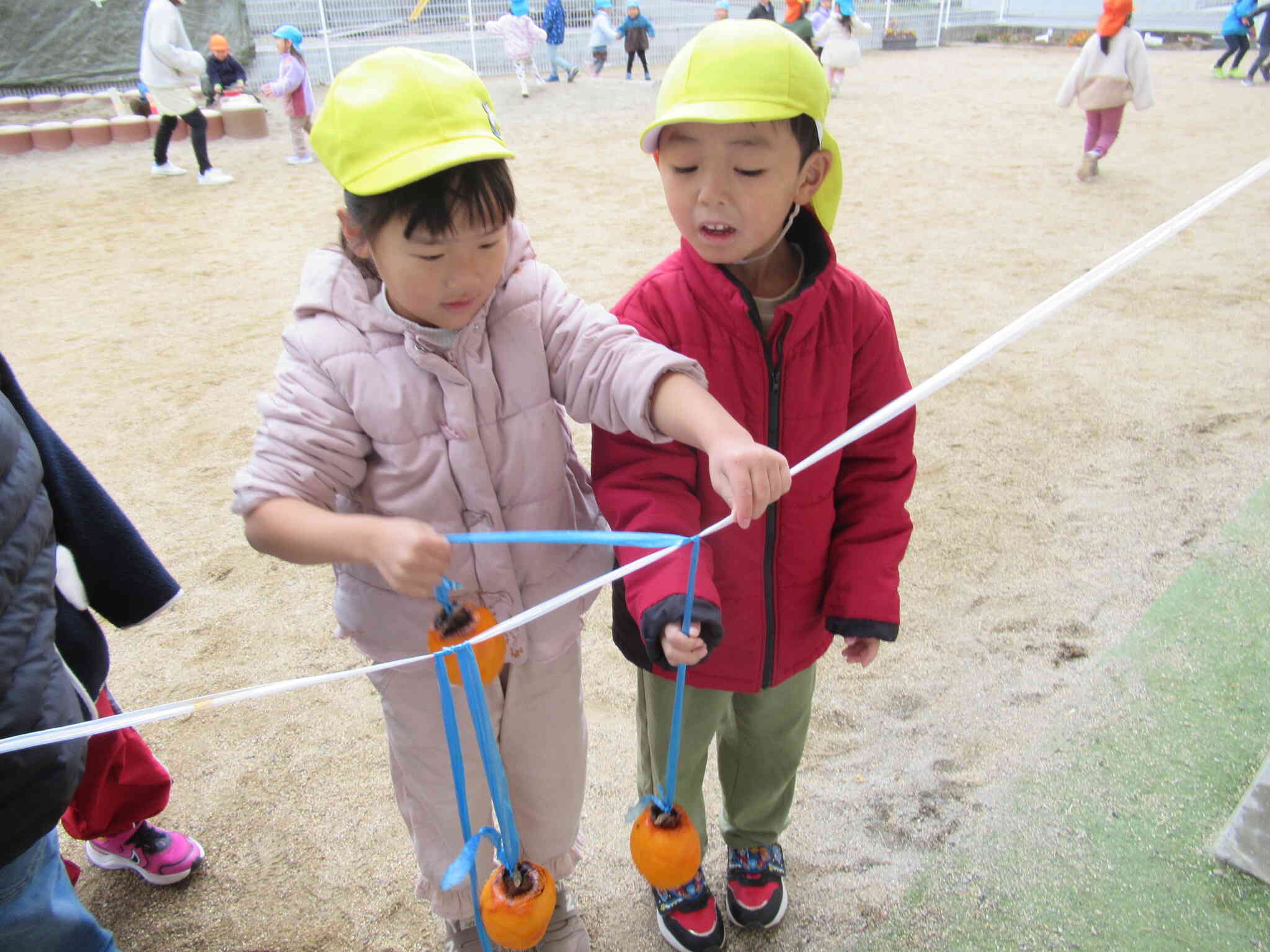 お友だちと協力して柿を吊るしました！「どうなるんかな？」と今から楽しみな様子です♪