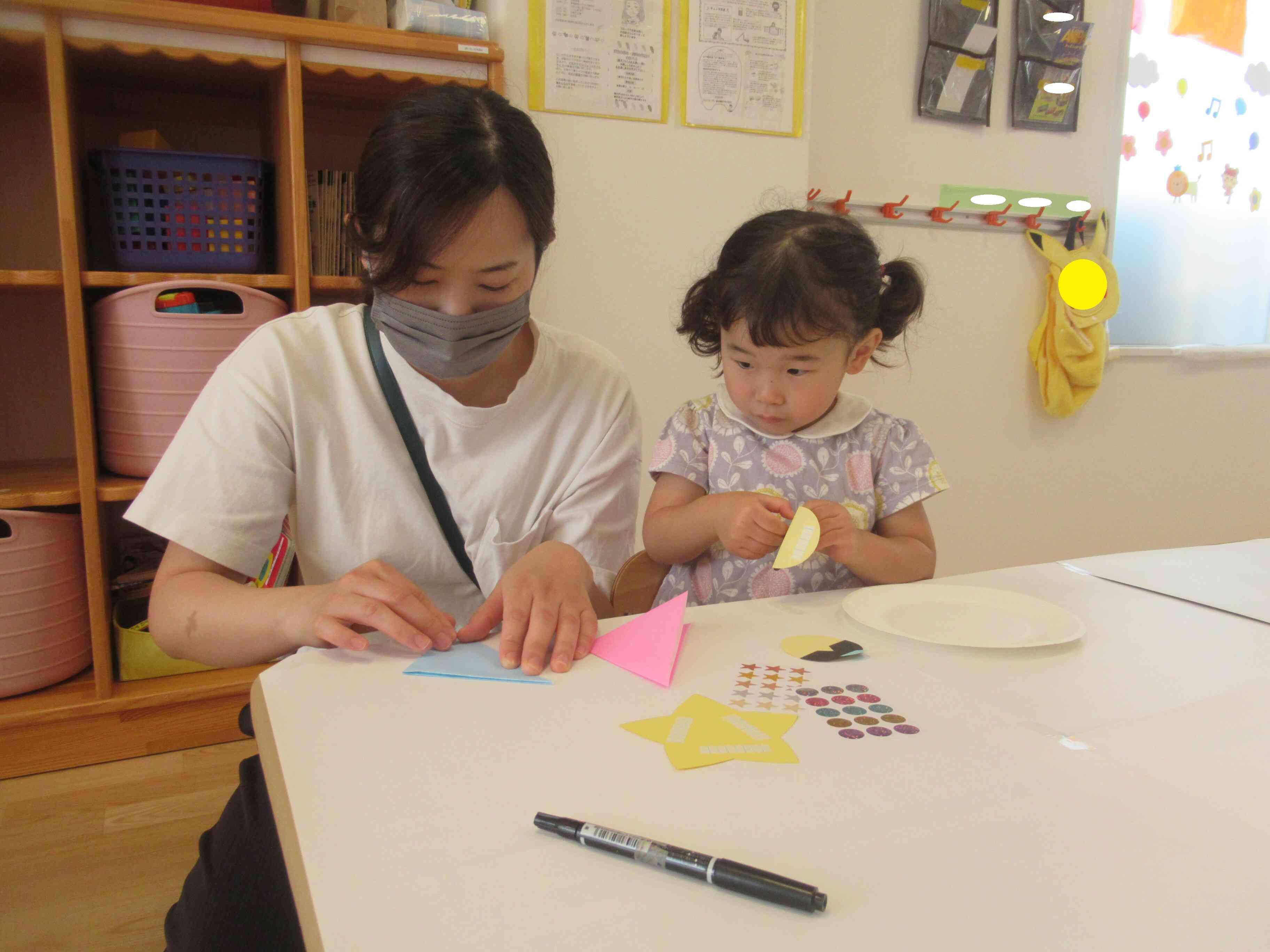 両面テープを準備しながら｢もう少しで出来るかな｣と折り紙が気になっているお友達。