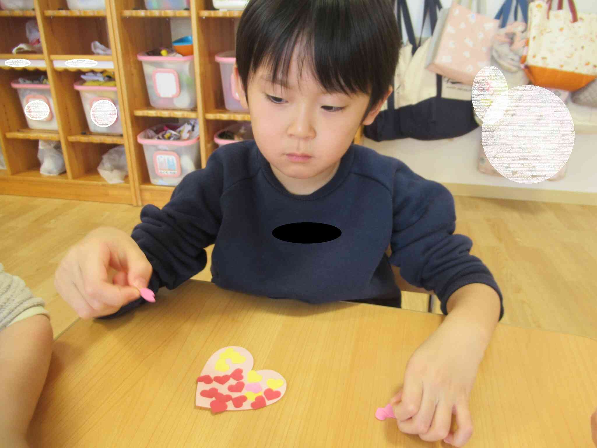 ハートの画用紙に小さいハートをたくさん貼りました