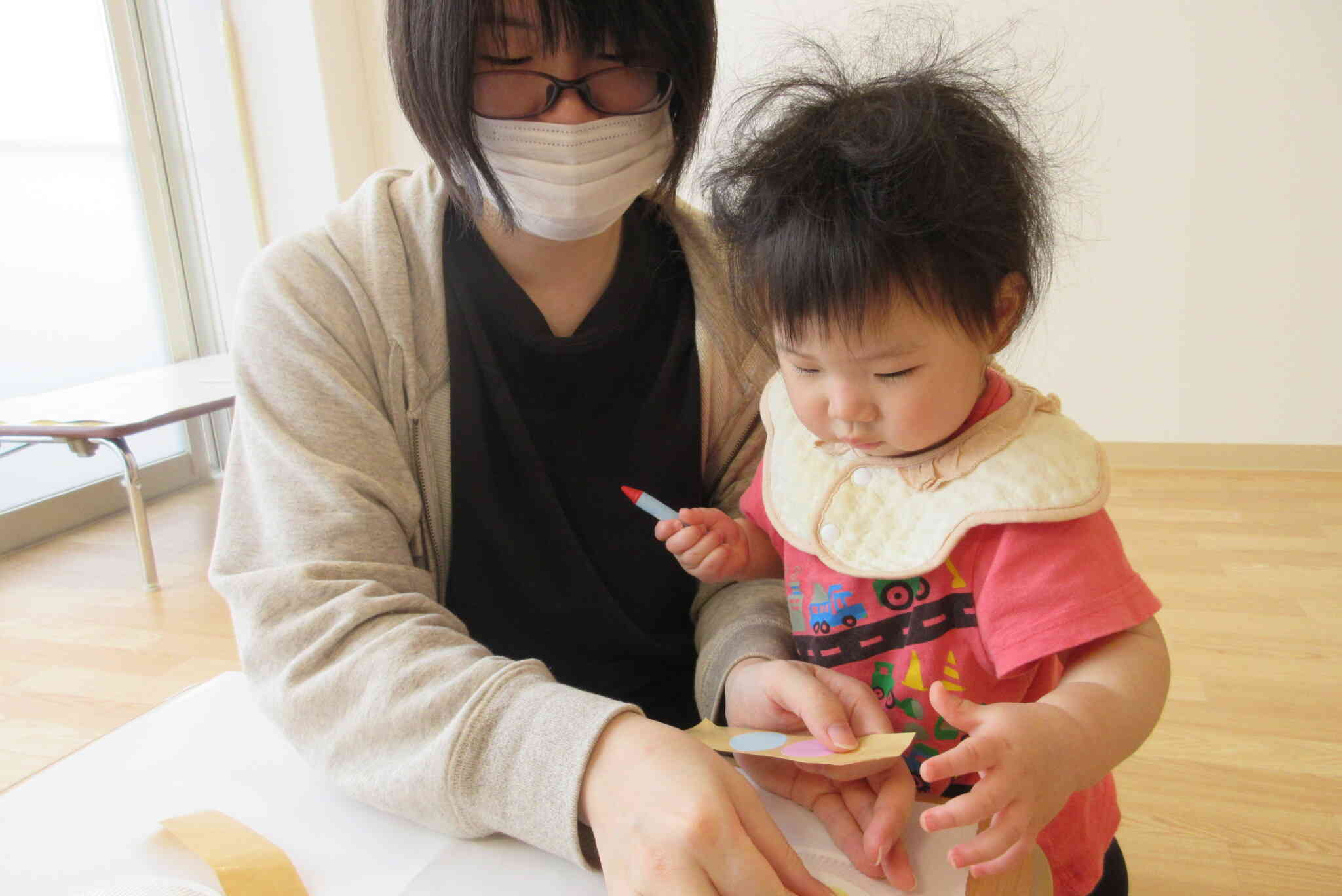 一緒にシール貼り…お母さんがどのシールを選ぶのか興味をもって観察しています