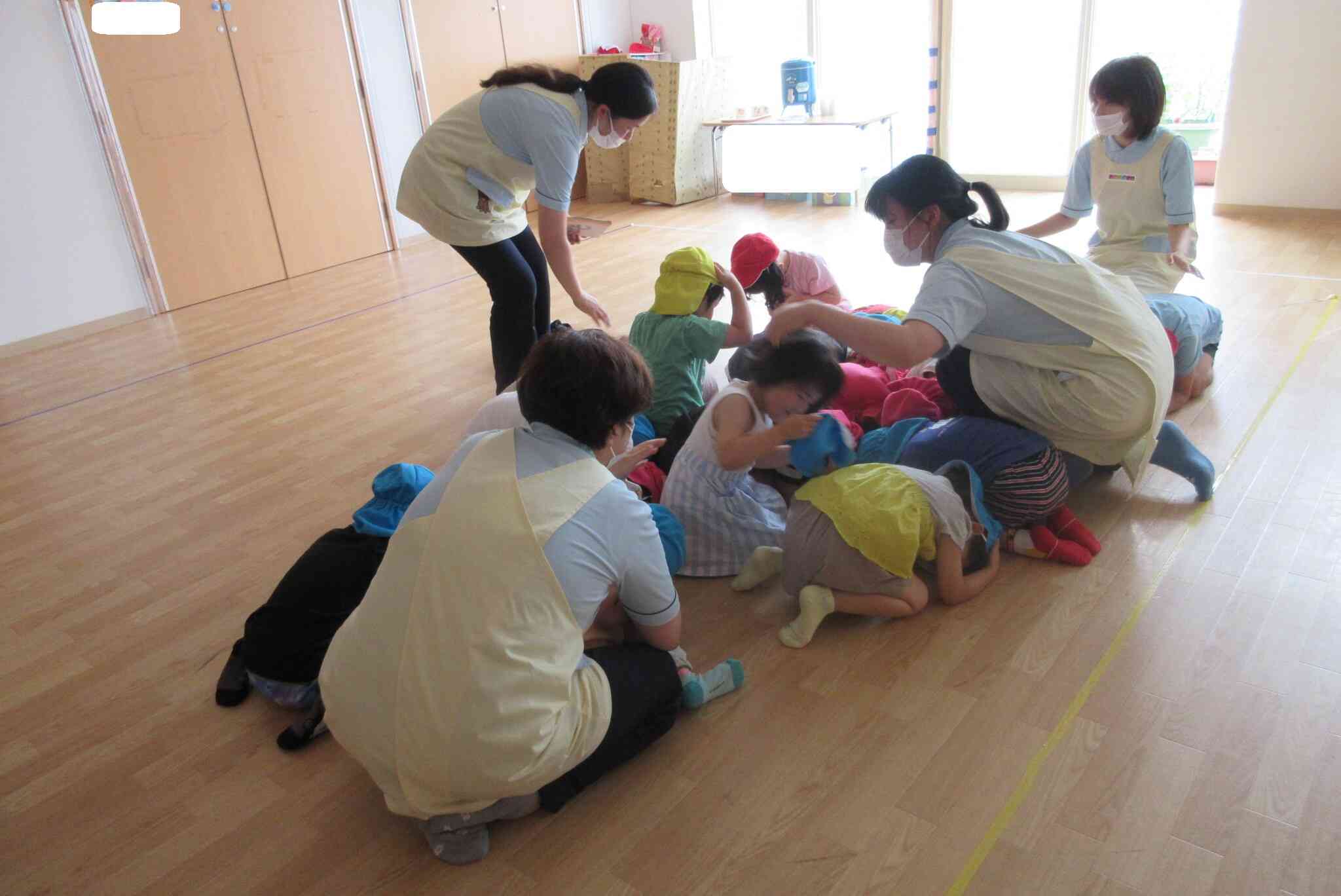 笛の音に気付くと、すぐに先生のそばに集まってダンゴムシのポーズを取って頭を守りました