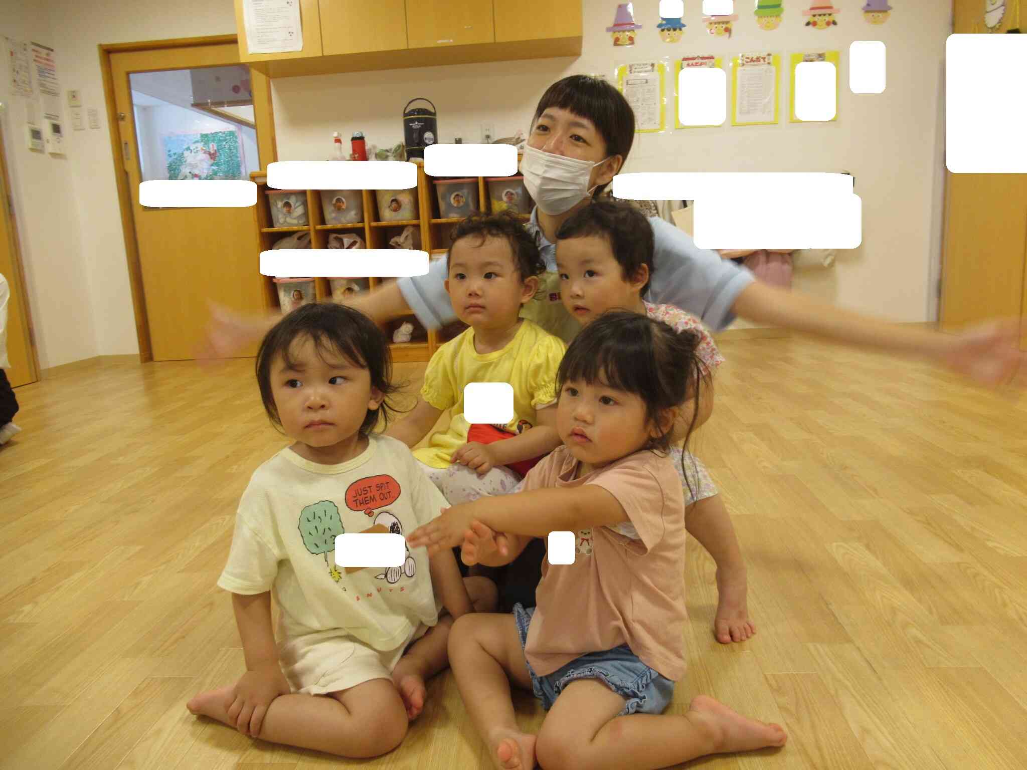 先生のそばで英語教室に参加する2歳児クラスのお友だち