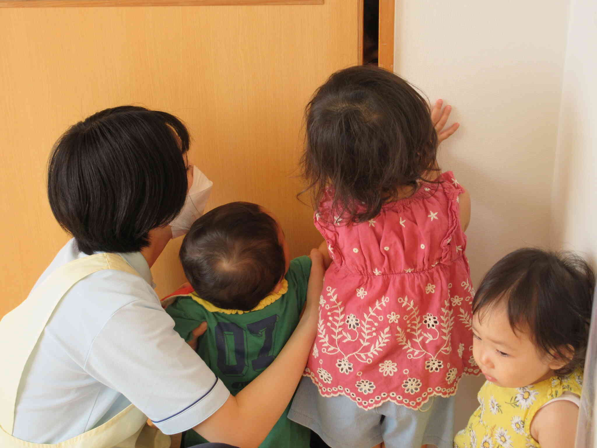 つかまり立ちに夢中のひよこ組のお友達を見て、うさぎ組も一緒に遊んでいます。