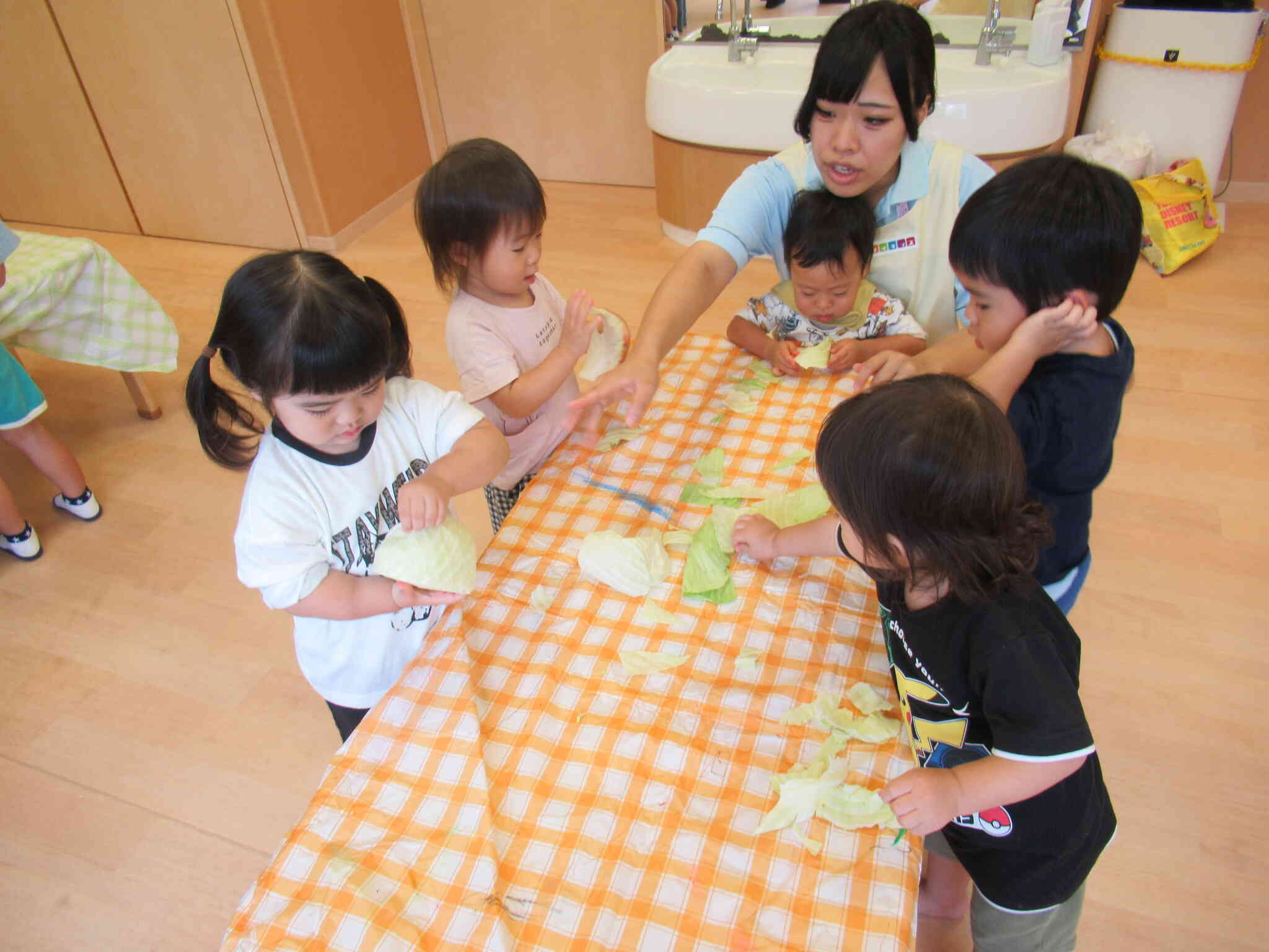 1歳児クラス：あひる組のお友だちも楽しくちぎることができました。