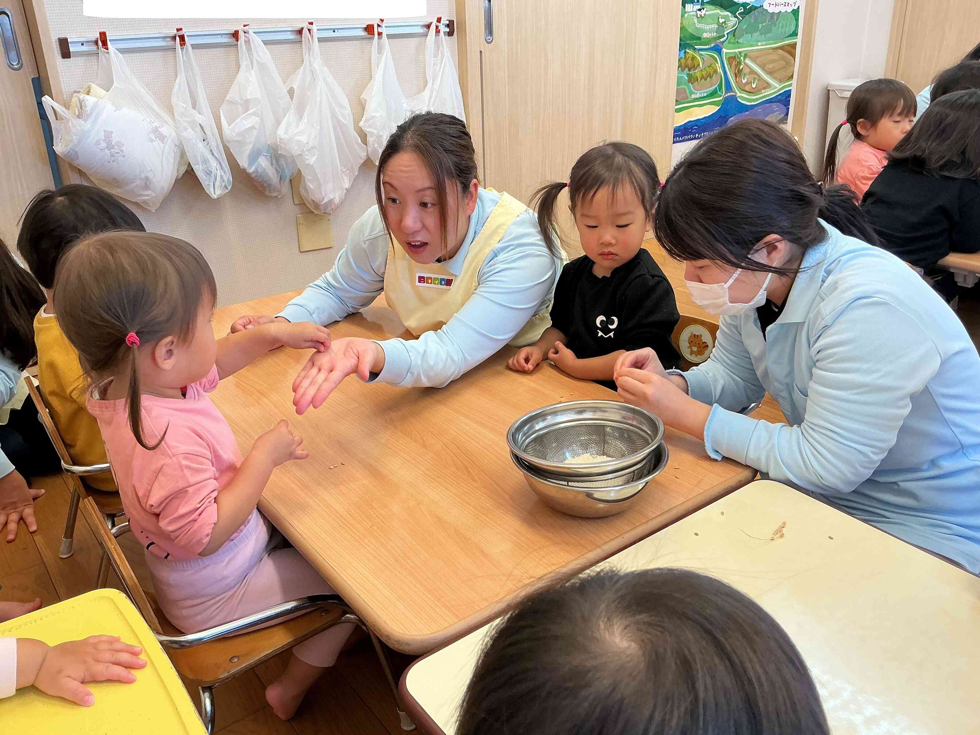 稲穂から稲を一つ一つとり、栄養士の先生と保育者が皮むき（脱穀）にチャレンジしてみました。