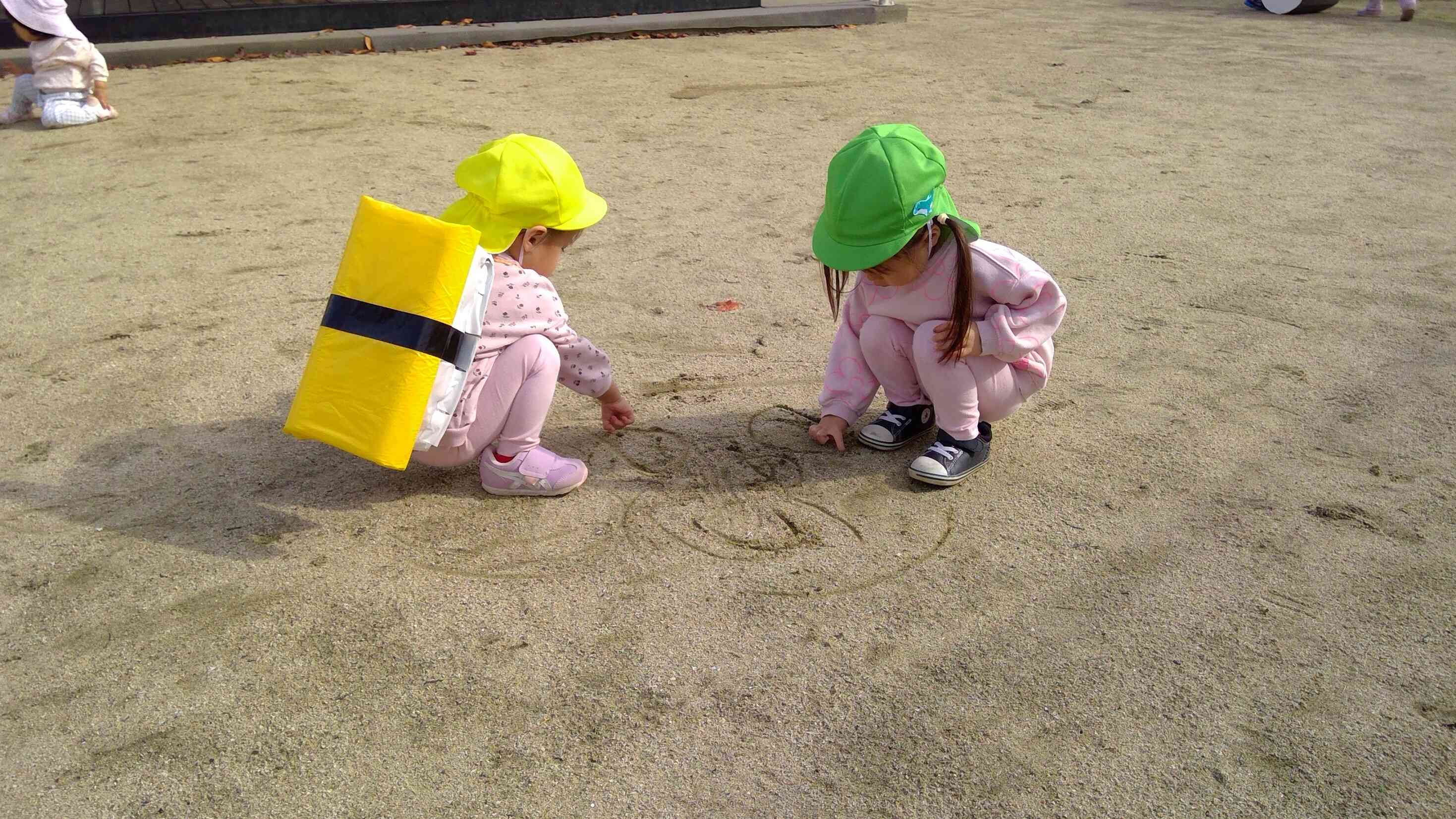 園庭の大きなスケッチブックにおもいっきりお絵描き。