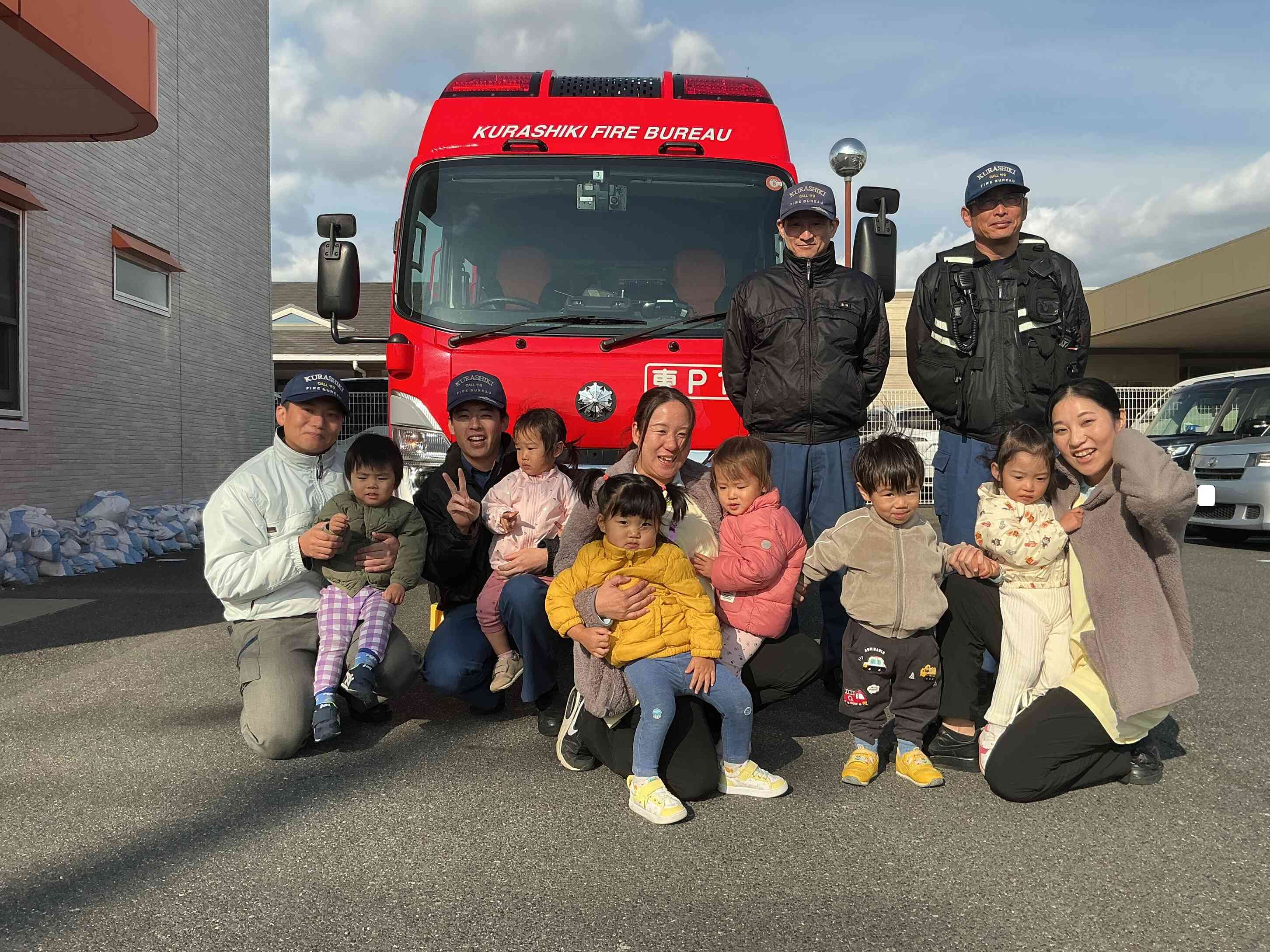 消防士さんを前にちょっぴり恥ずかしいあひるぐみさん（1歳児）。