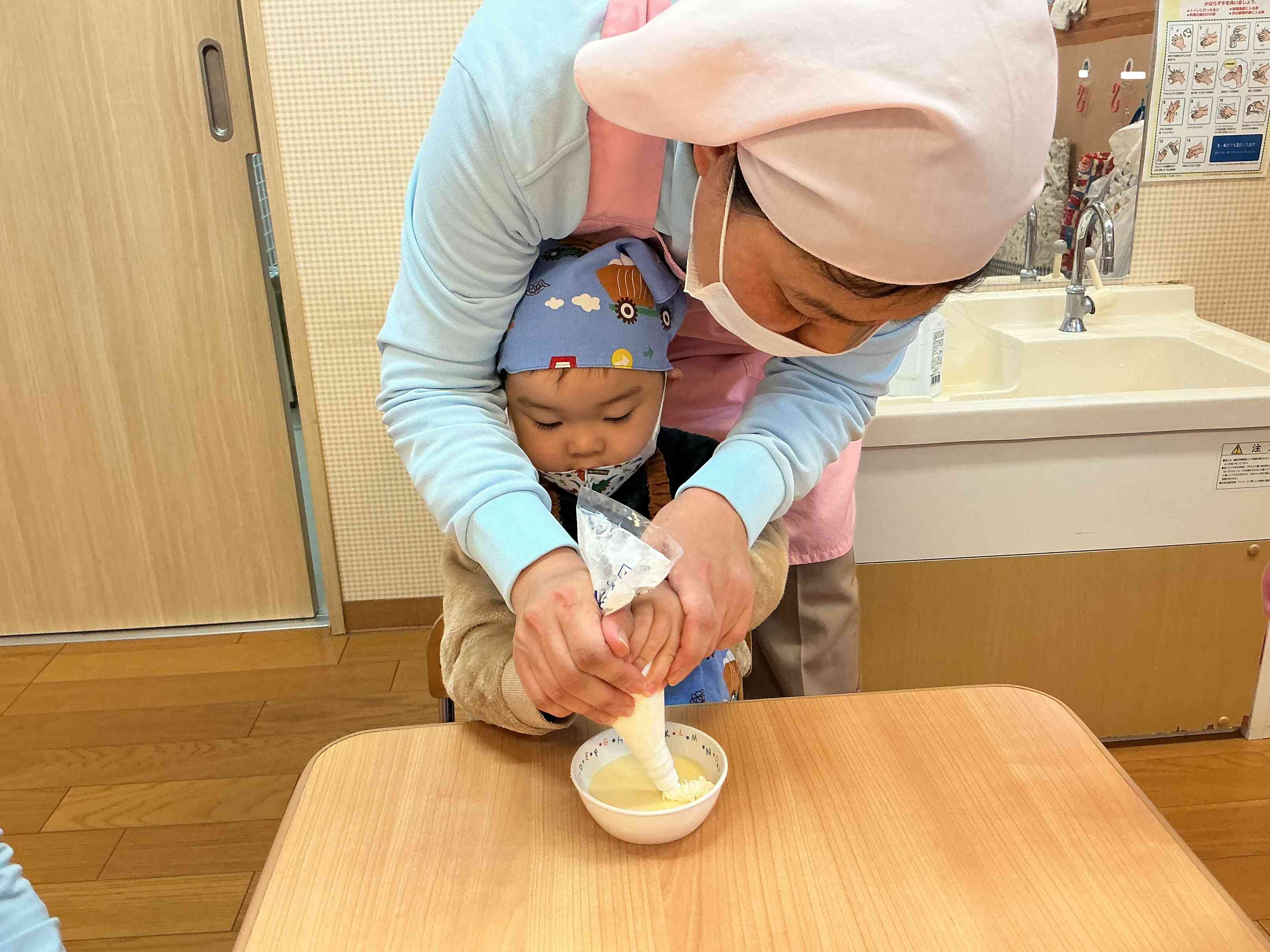 生クリームホイップしぼりは、給食の先生と共同作業です。