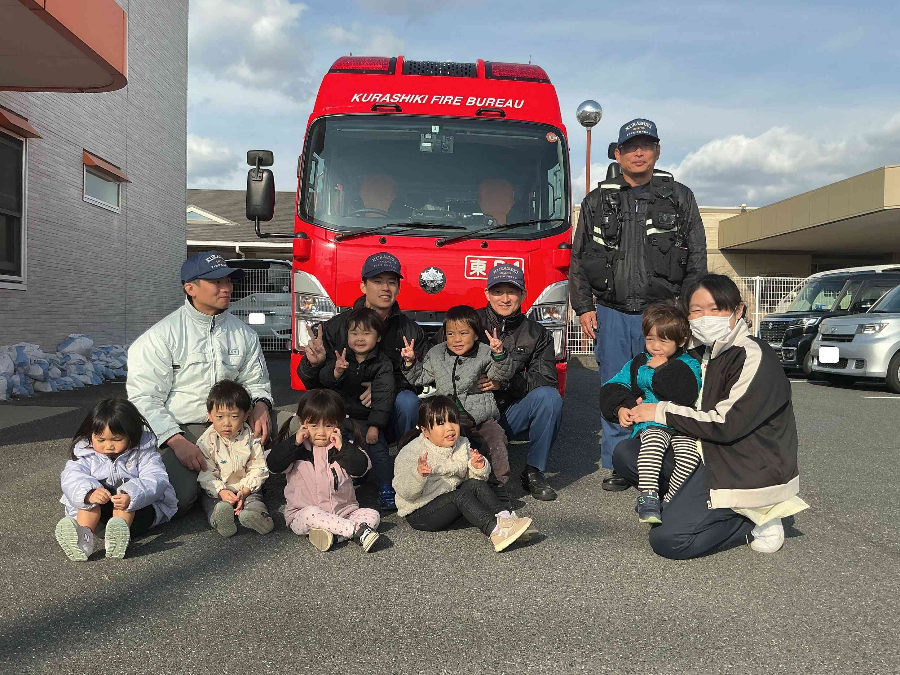 憧れの消防士さんと一緒にハイチーズ。大喜びのうさぎぐみさん(2歳児)。