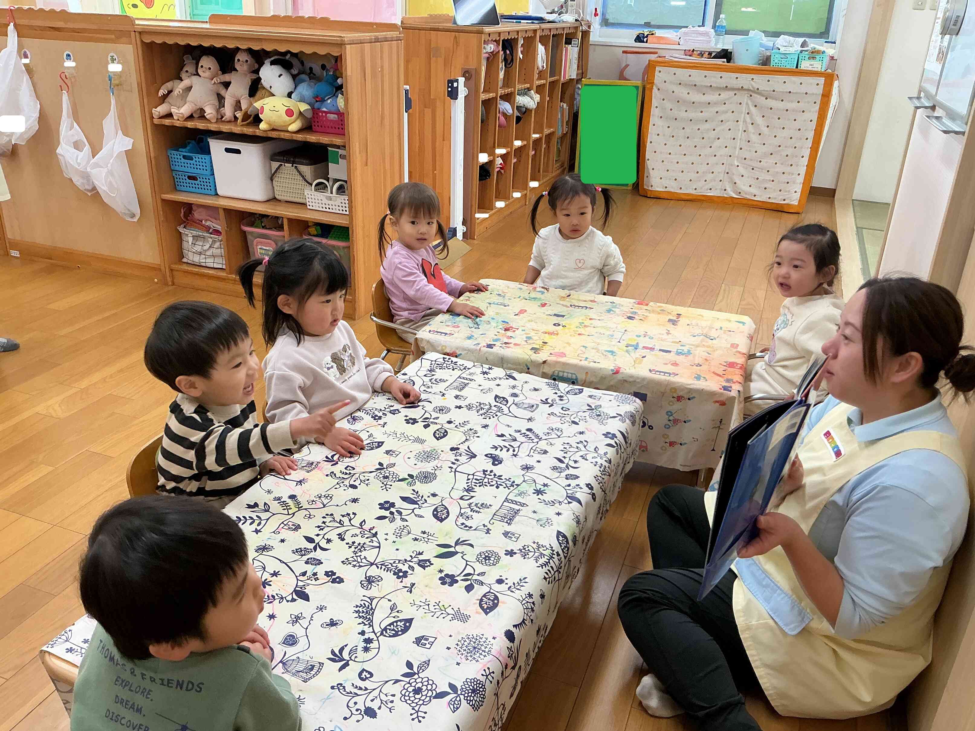 保育者の絵本の読み聞かせ。興味津々で集中して見ていますよ。