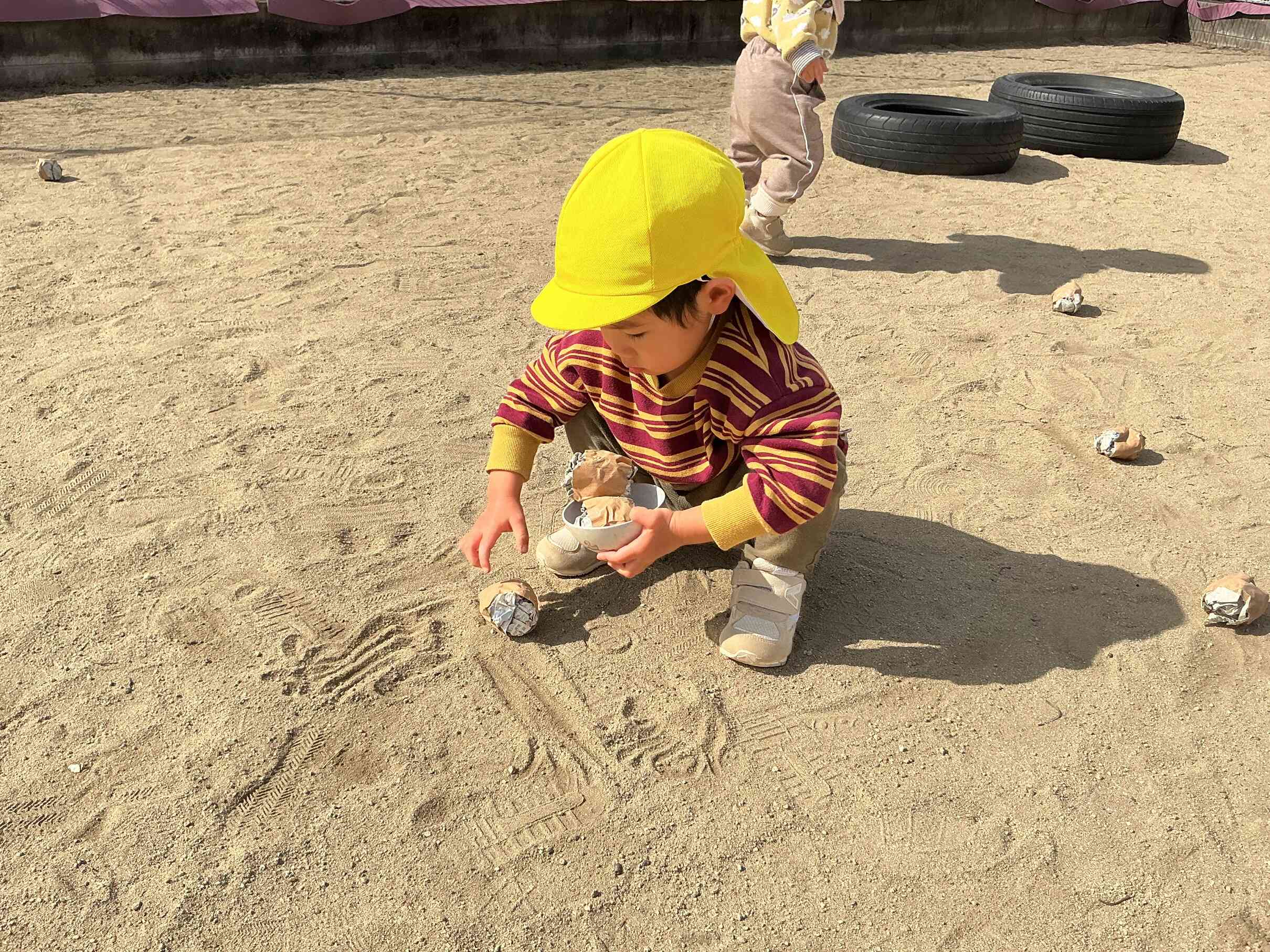 豆まきの豆を小さいお椀に上手に入れるおともだち。