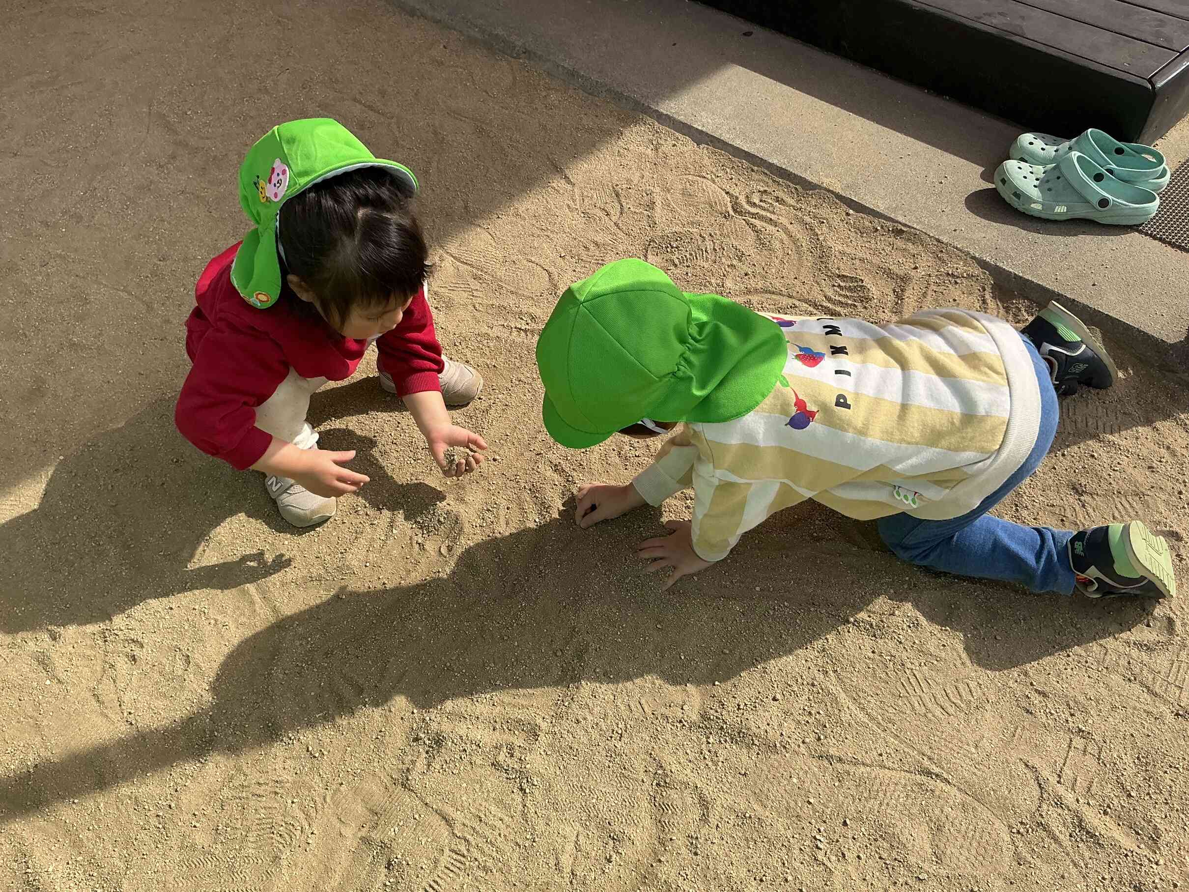 お砂の中に小さい何かを見つけて指先で上手につまんでプレゼント。