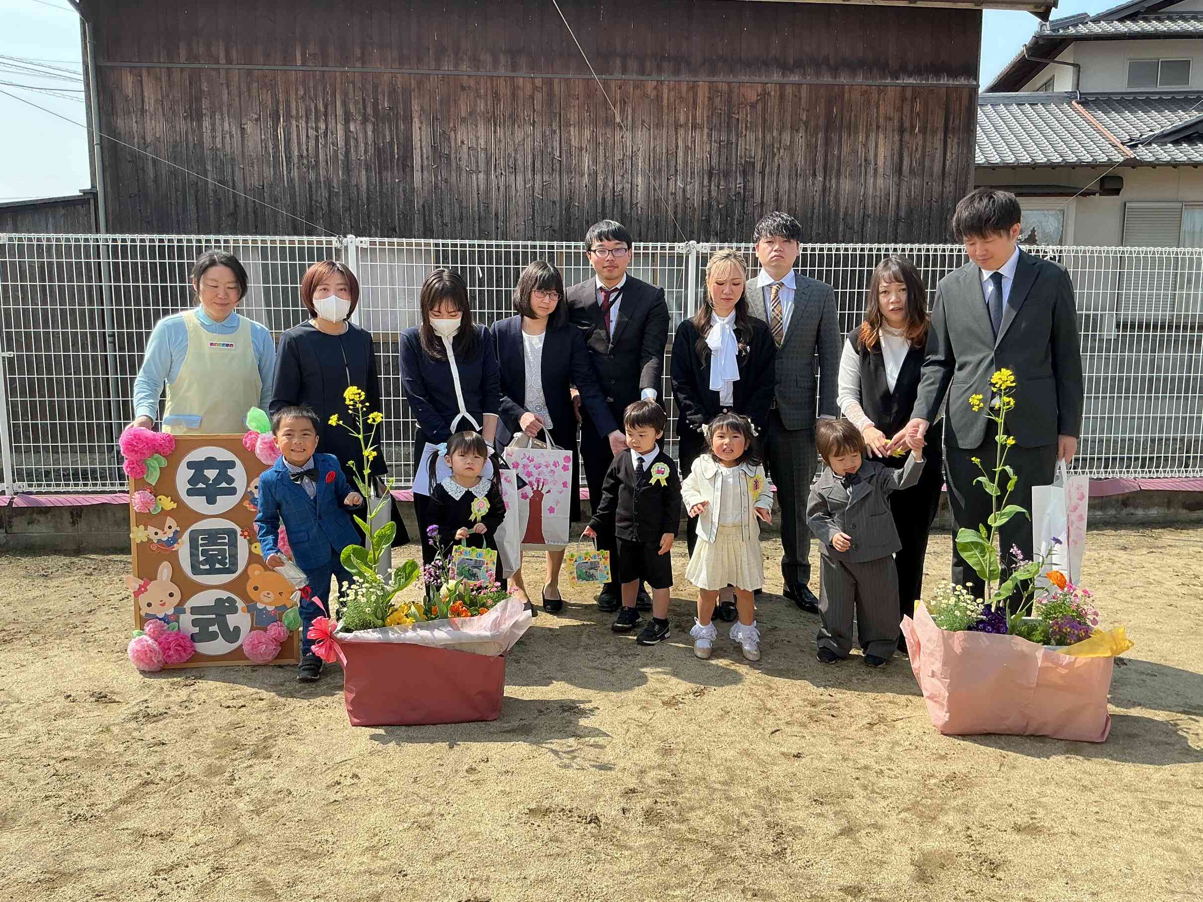 ぽかぽか春の陽気で、園庭の桜がちらほら咲く中、みんなで記念撮影。
