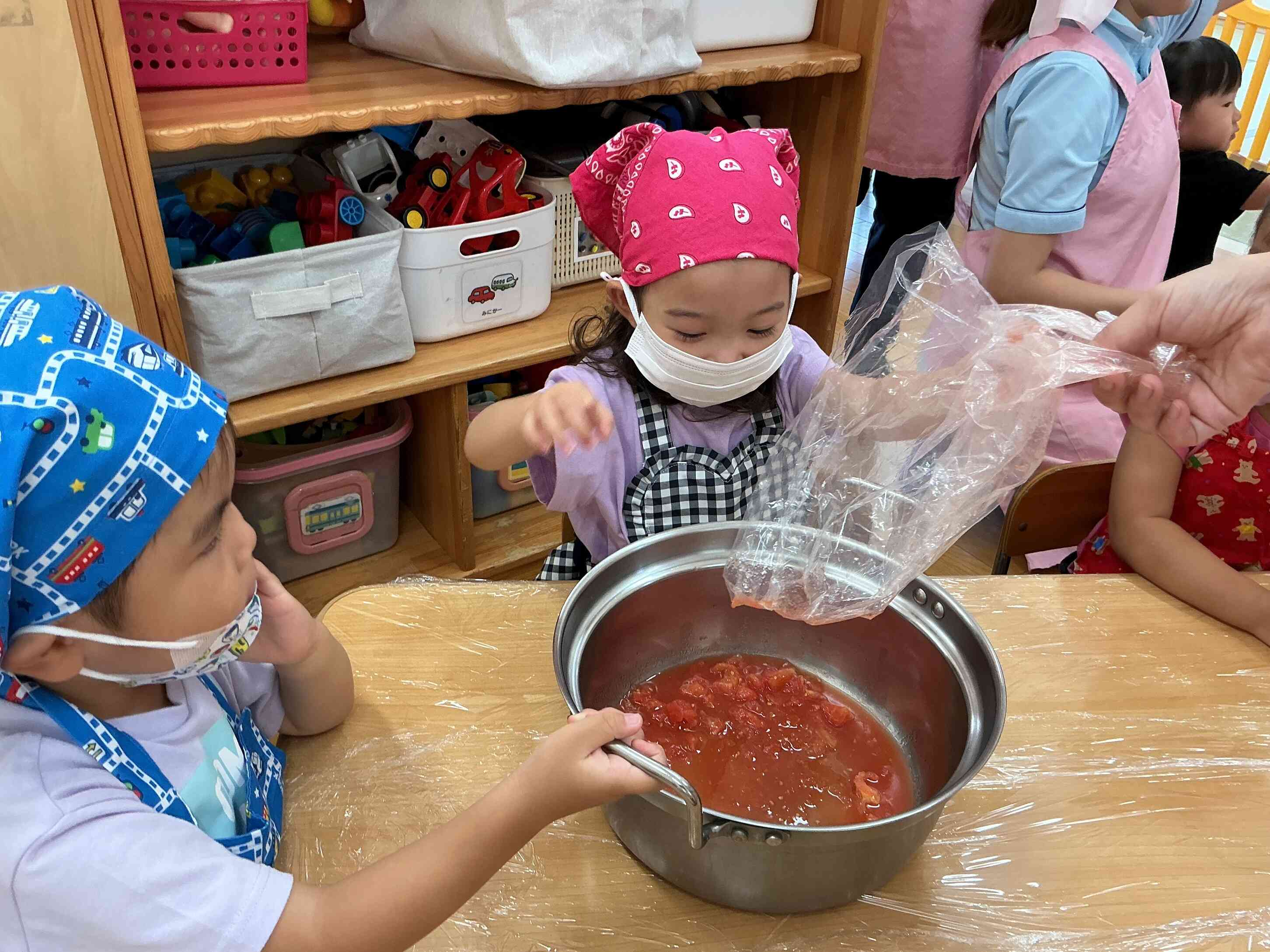 子ども達がもみもみしたトマトを大きな鍋に入れました。