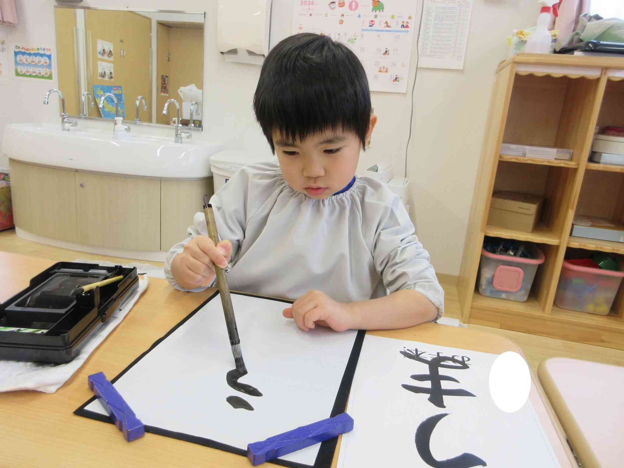 手本を見ながら真剣に書いています