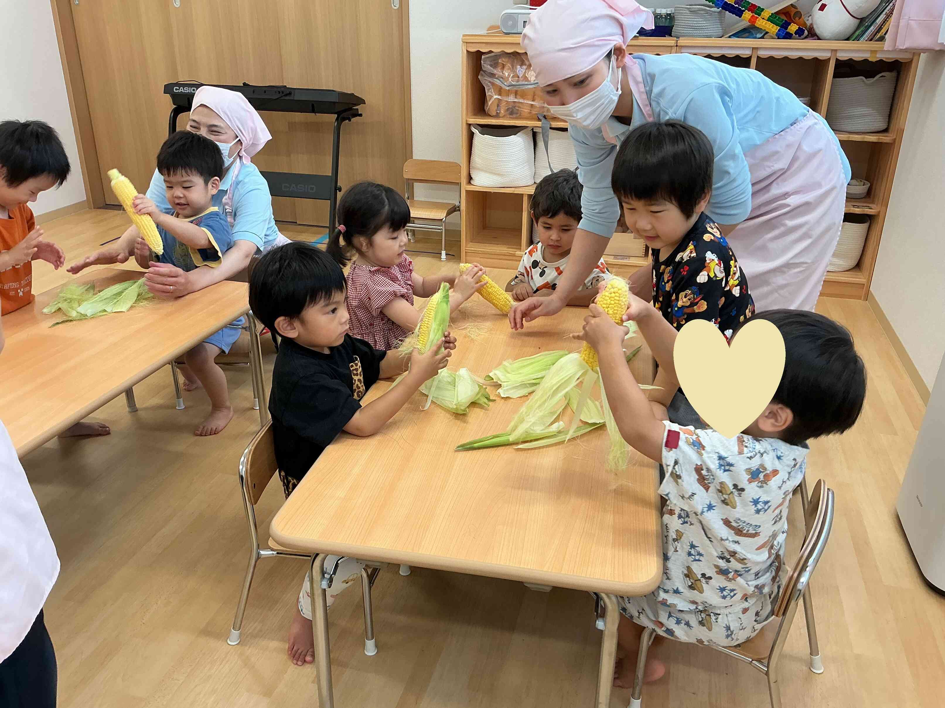 8月の食育　トウモロコシの皮むき　りす組（３歳児）