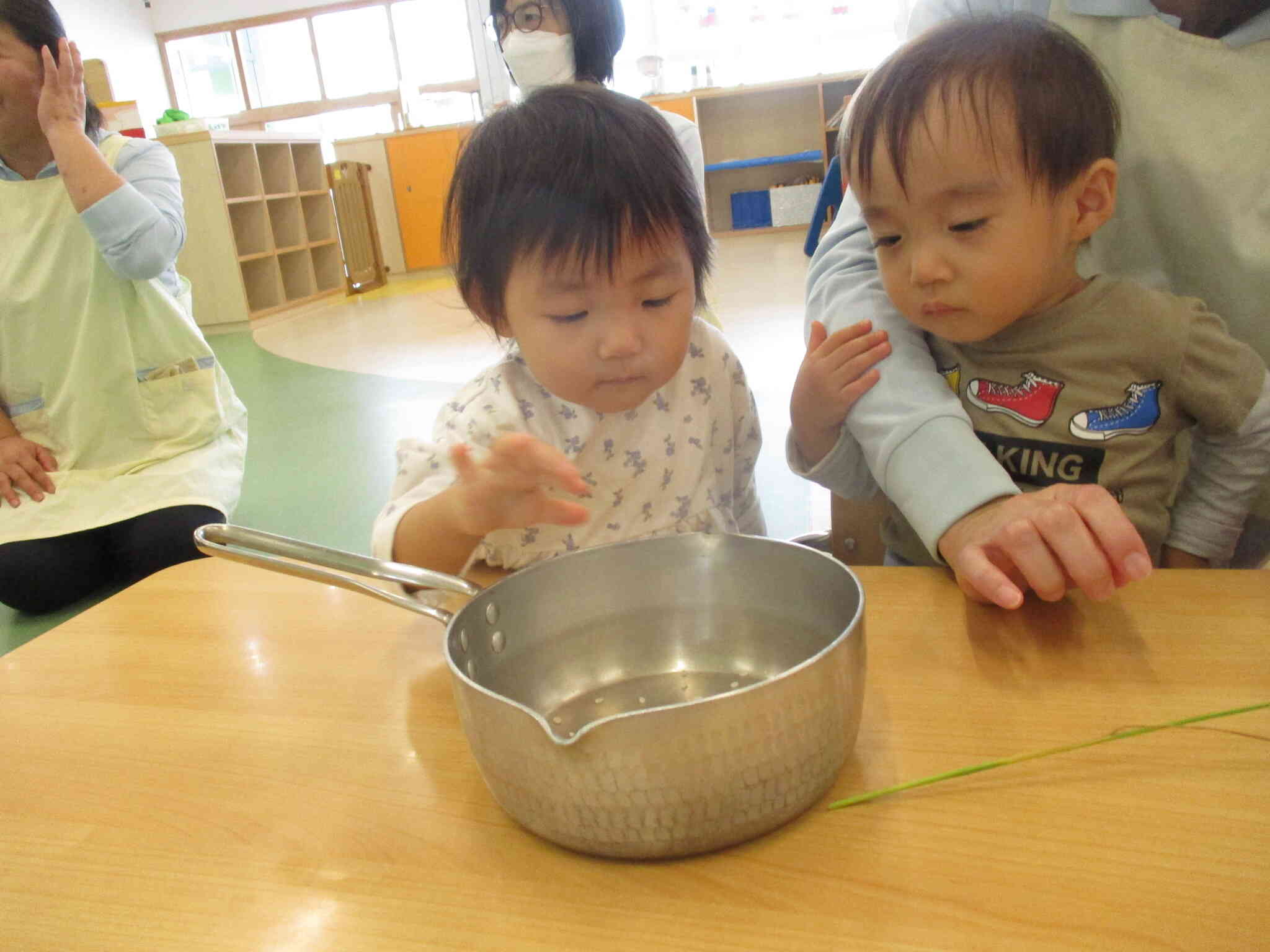 お米が入ったお鍋を見つめています