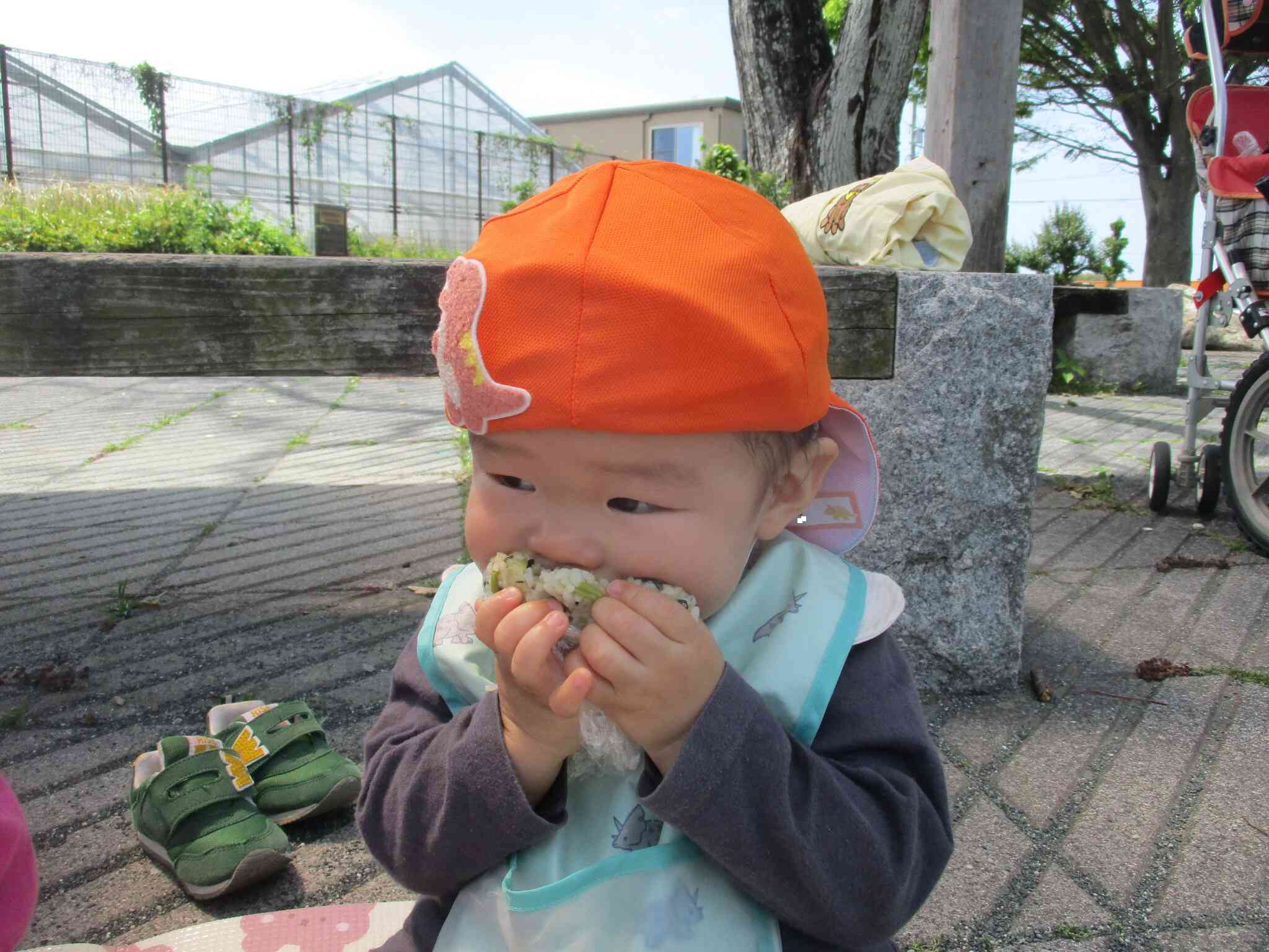 おにぎりをパクッ!美味しいね♪(いっぱい入りすぎない様に保育士が見守っています)