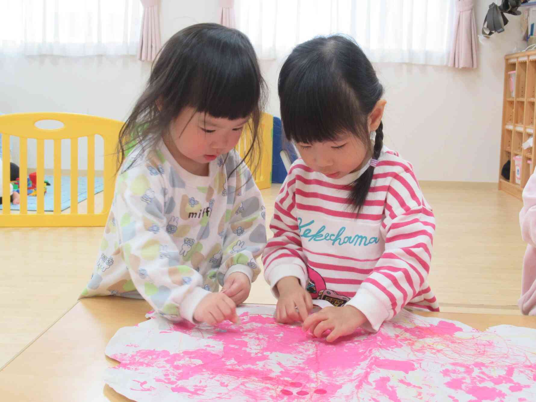 春の色だね♪　絵の具やクレヨンで色付けした紙にお花のシールを貼りました♪