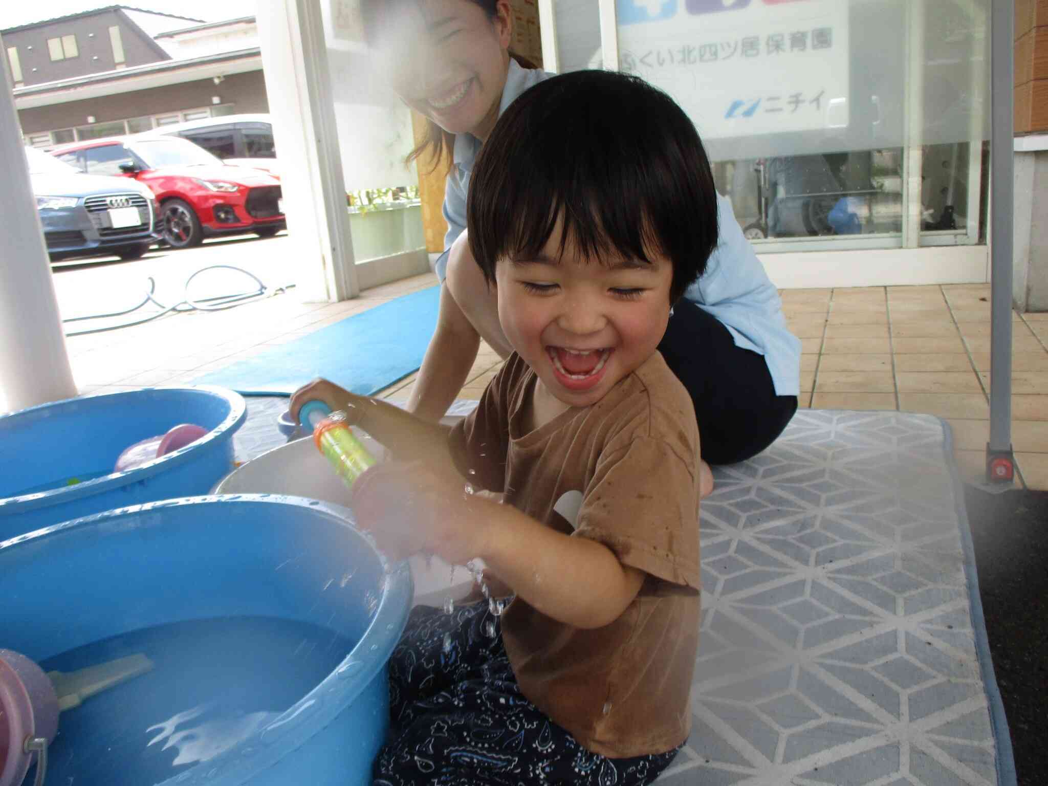水鉄砲の口を手でふさぐとプシャーっと噴水のように出てくることに気が付き大喜び♪