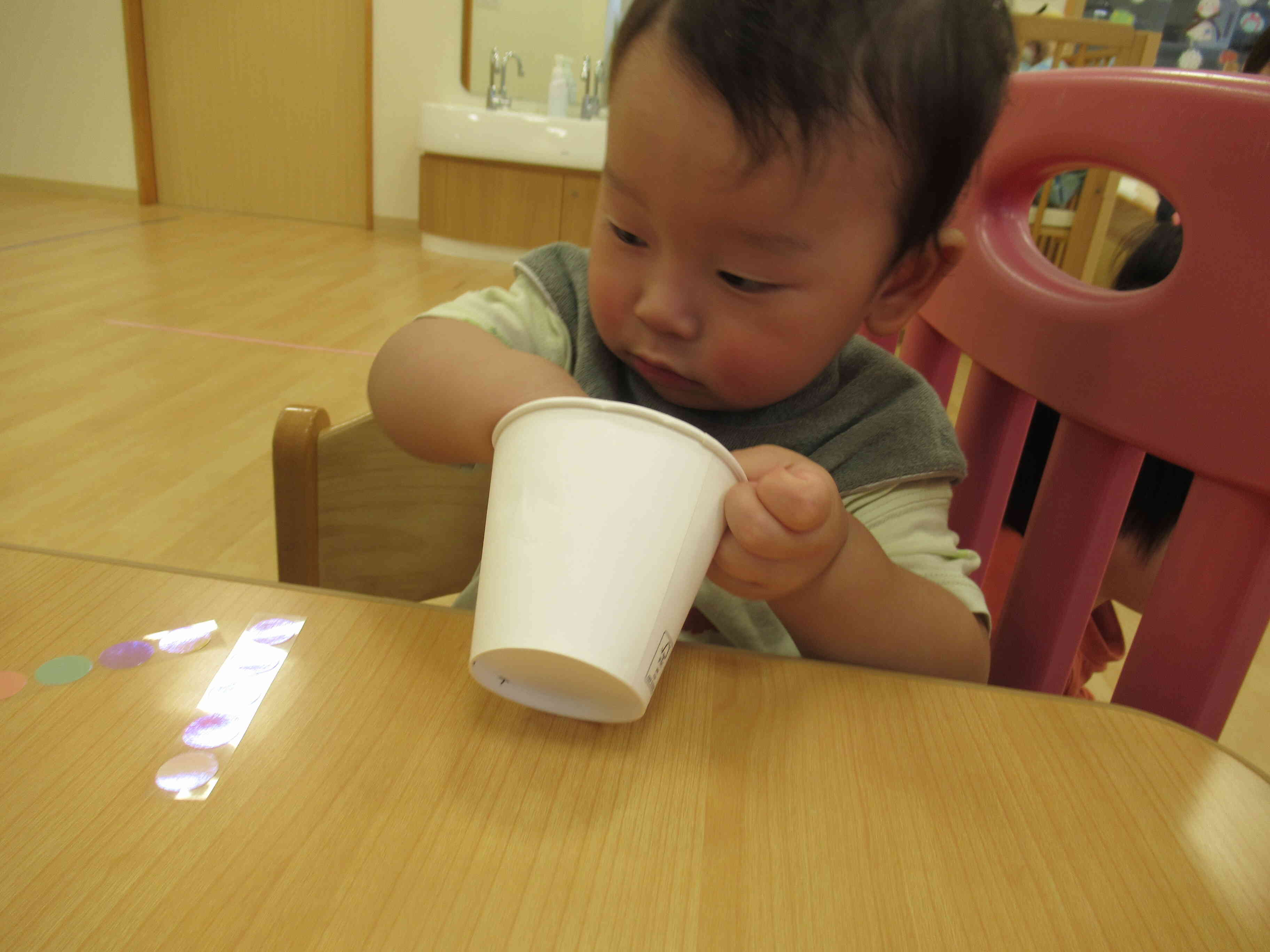 紙コップの中が気になるお友だち。何か入っているかな？と手を入れて探っています