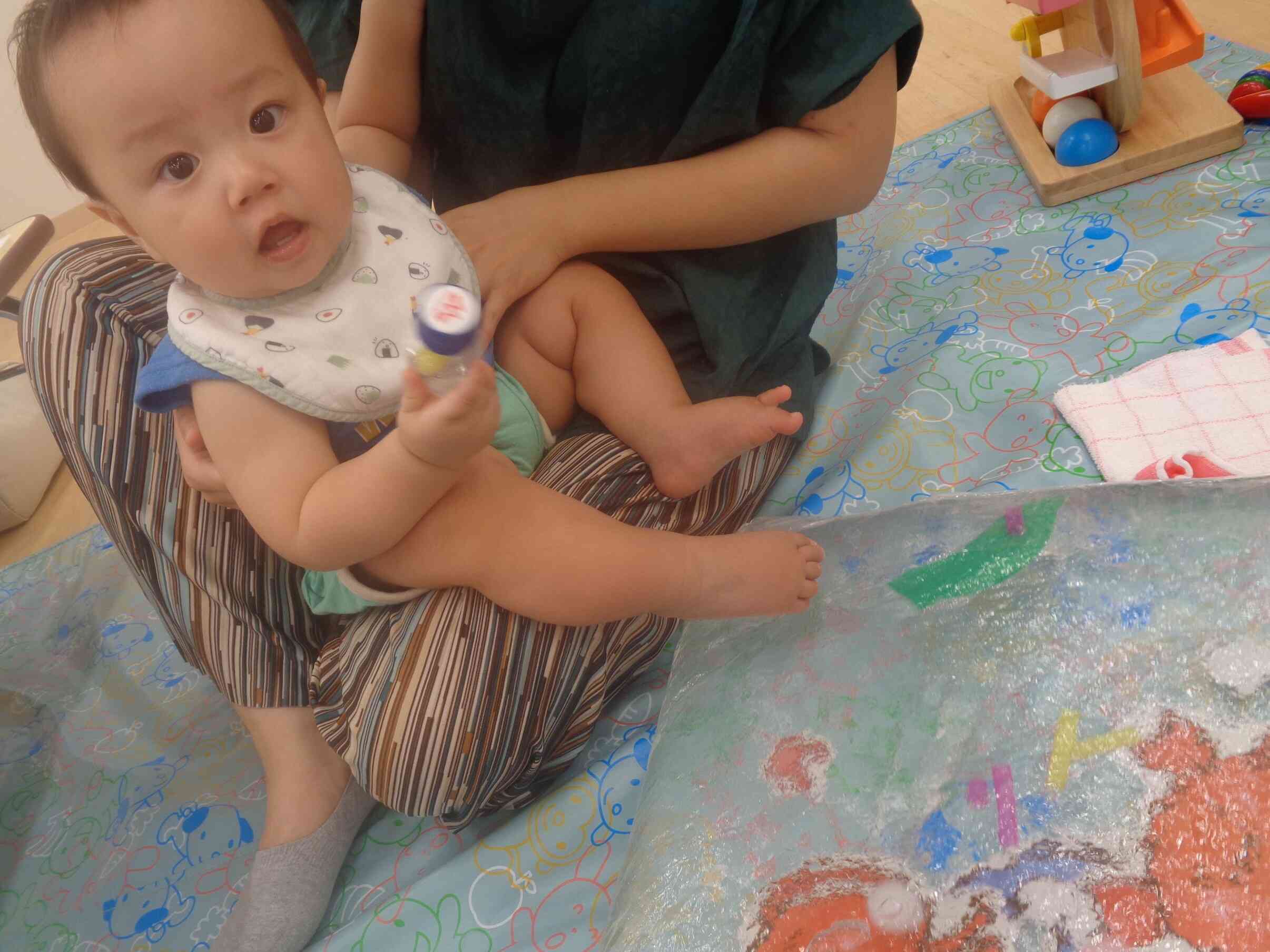 『センサリーボトルとウォーターマットで遊んでみよう』センサリーボトルを手に持ったり保育士が振って見せたり、転がしてみたりと音を楽しみました♫ウォーターマットでは、足で感触を確かめていました。