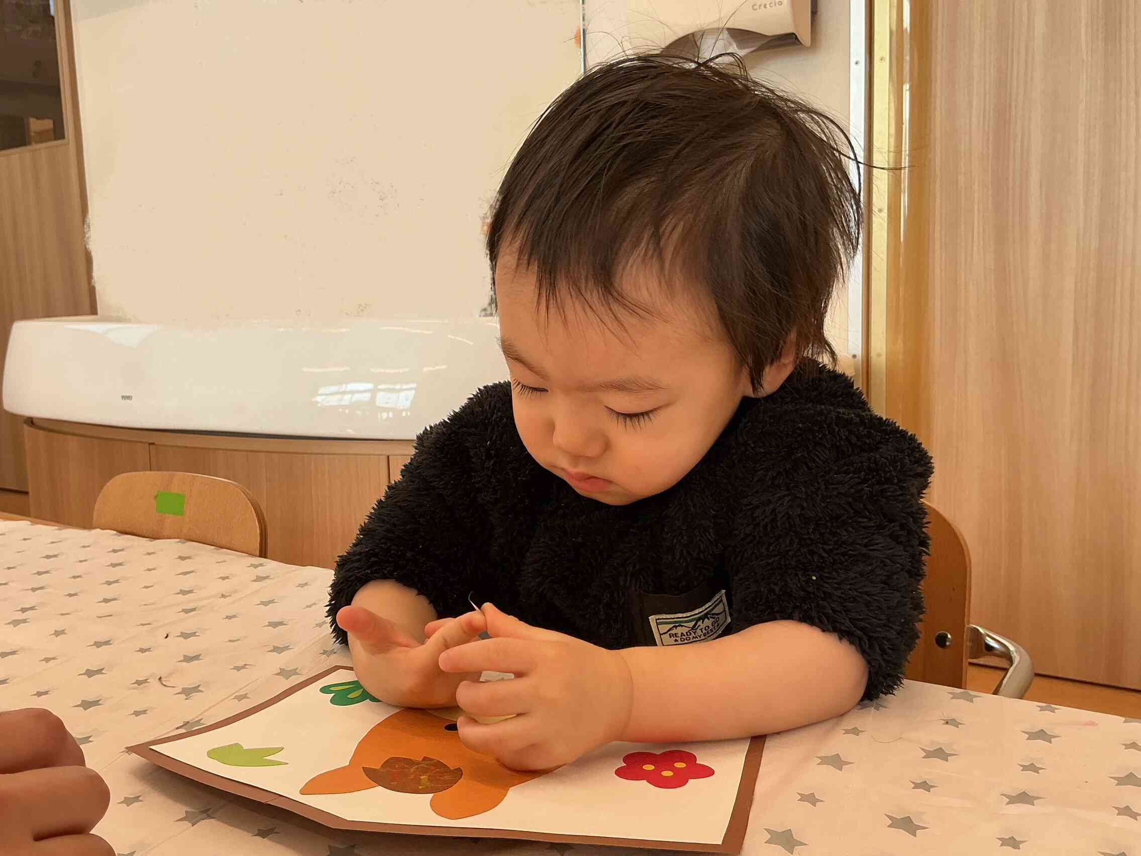 指からシールを頑張って剥がしています