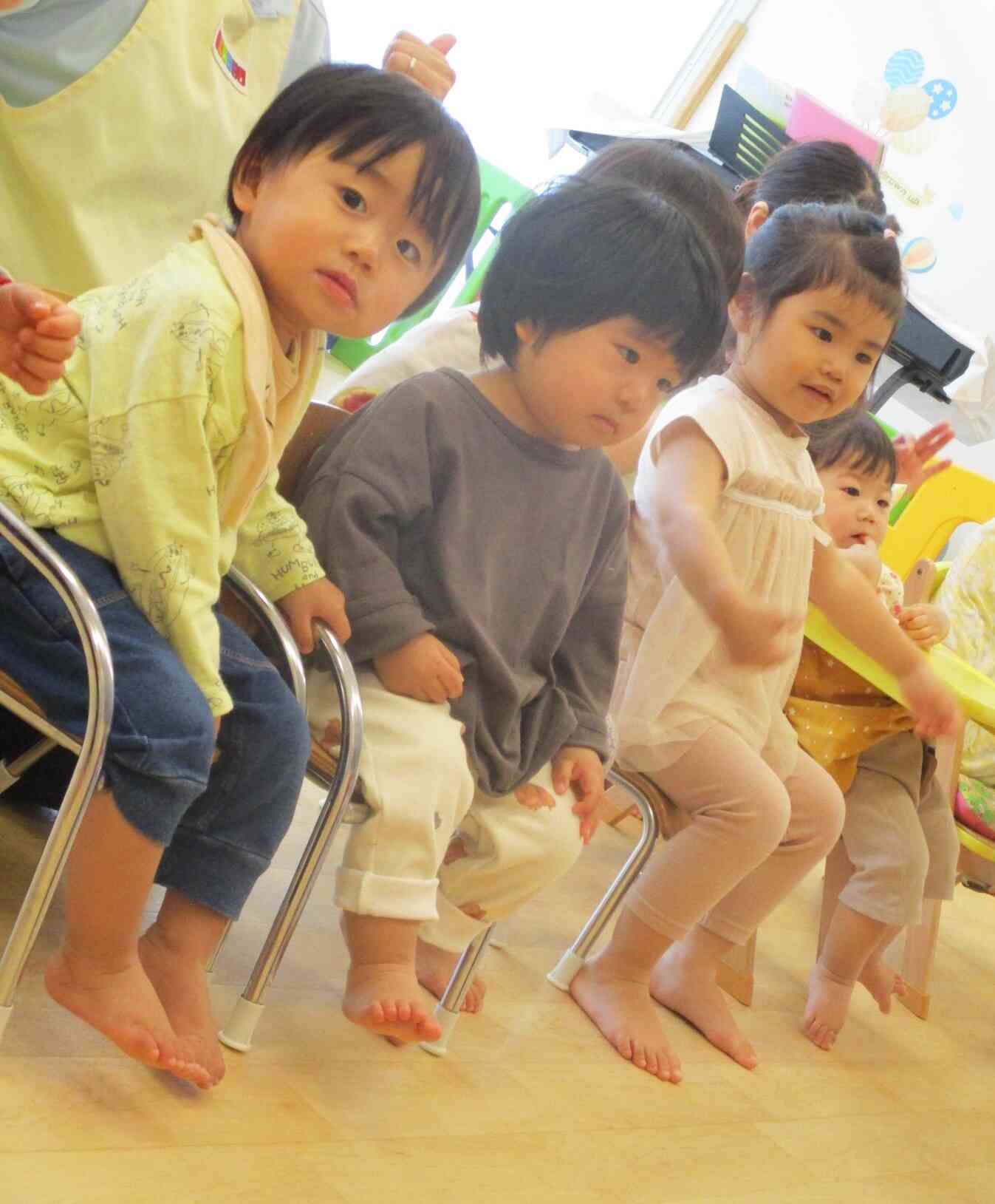 写真を撮る先生を見つけたあひる組（１歳児）の男の子。