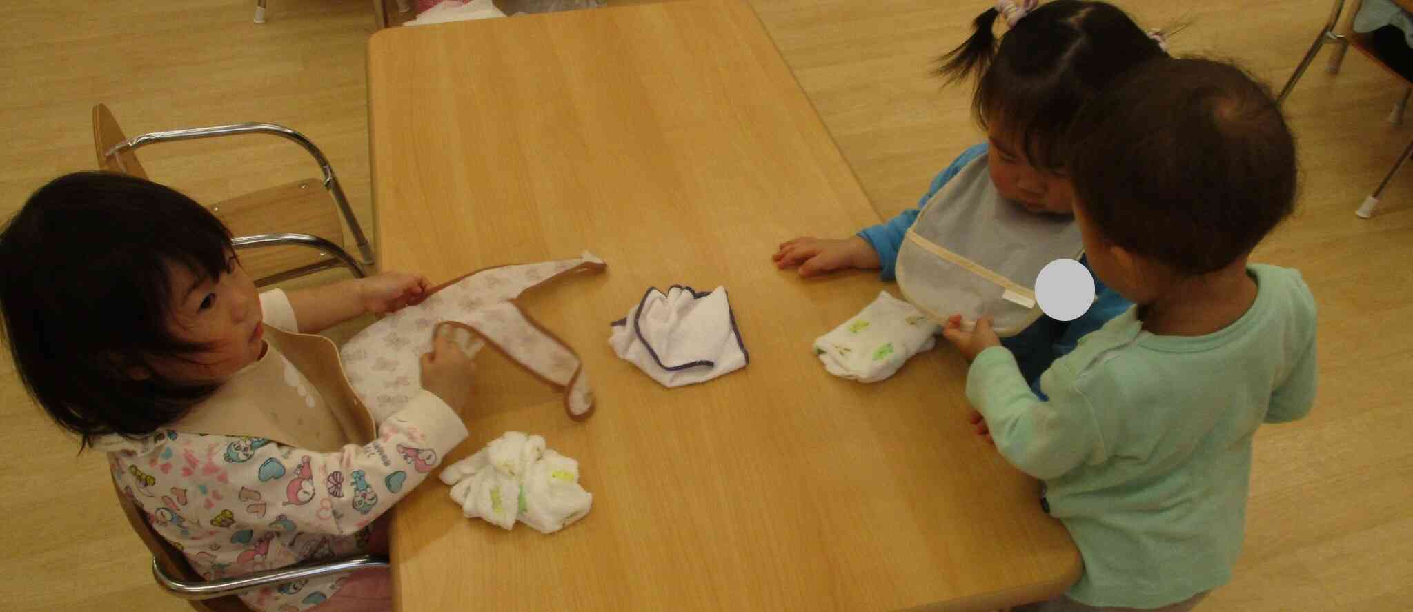 お友達がつけているエプロンが気になるひよこ組(0歳児)の子