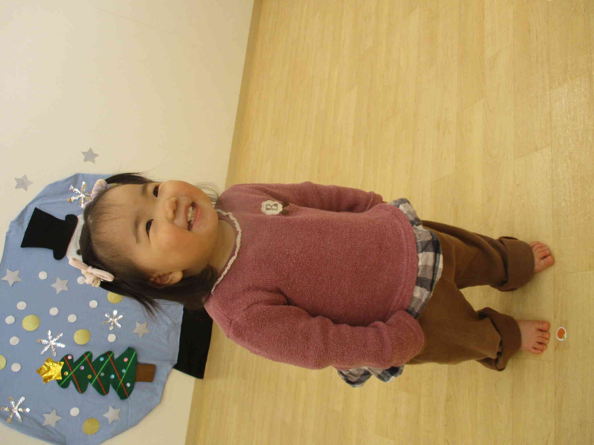 ひよこ組（0歳児）の女の子は自分の番になると笑顔で立ちます。