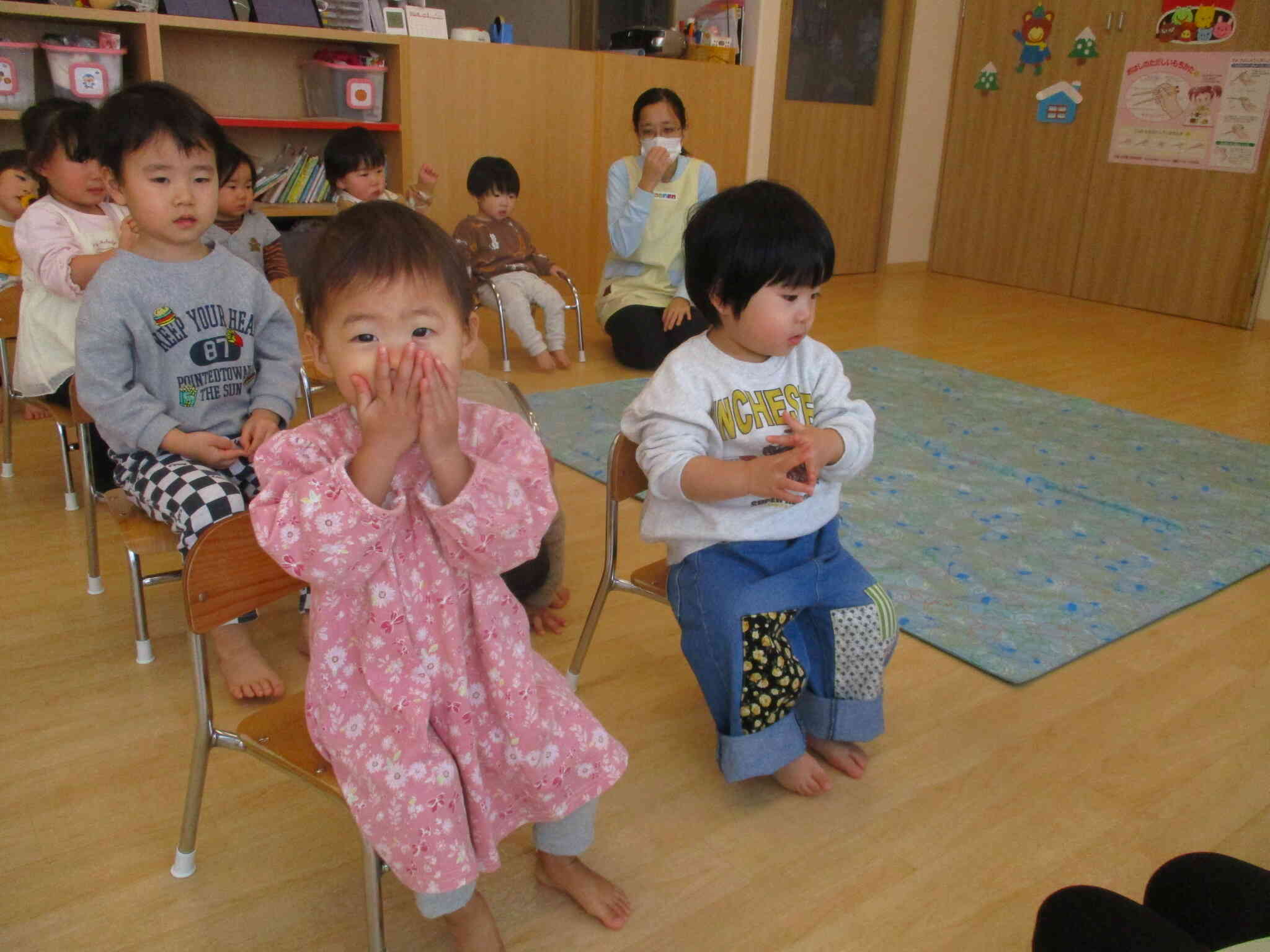 「こんこんくしゃん」の曲に合わせて手でマスクを作っています。