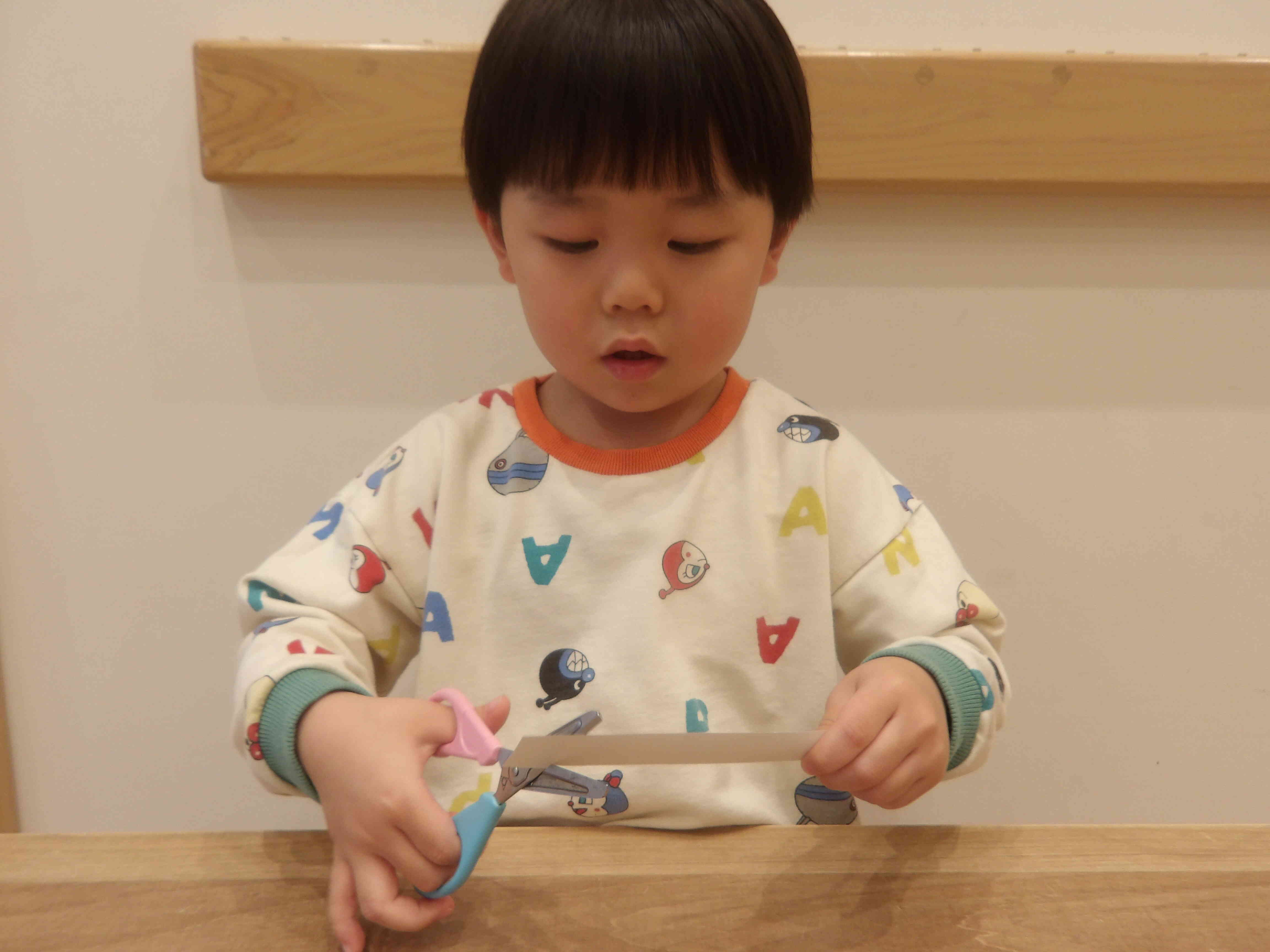 銀色折り紙をはさみで切って雪を作りました。