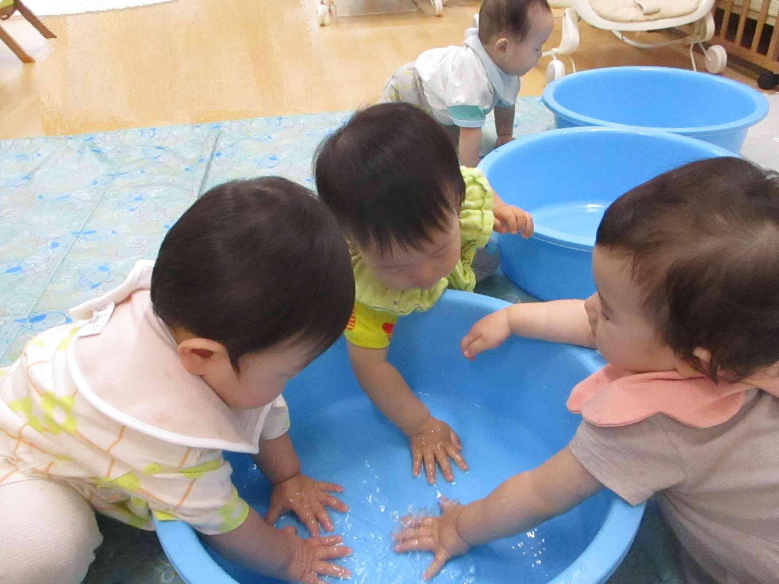 室内で水遊び～　0歳児クラスのお友達も楽しく水遊びをしています。