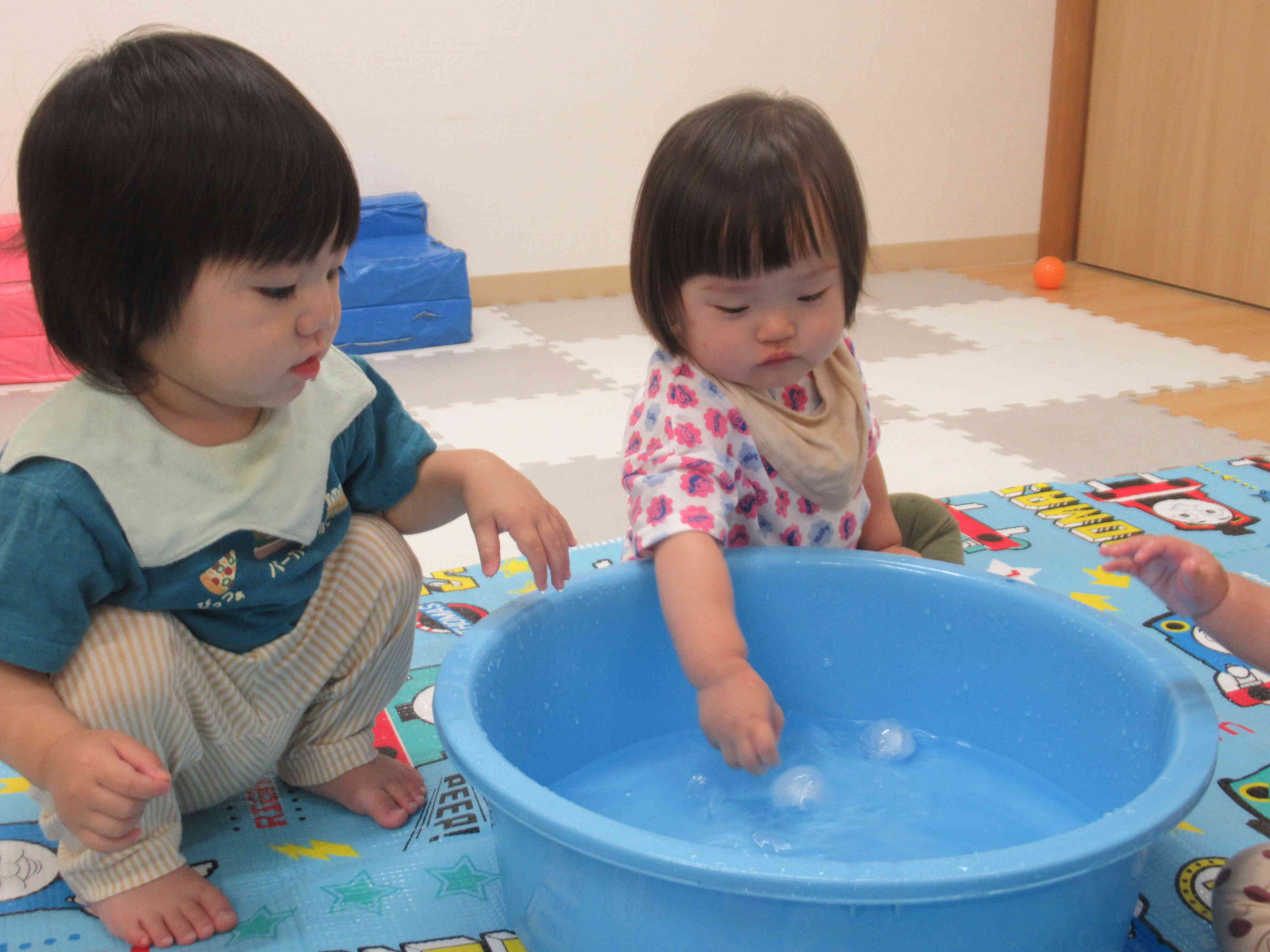 室内で水遊び~ 0歳児クラスのお友達も楽しく水遊び(氷遊び)をしています。