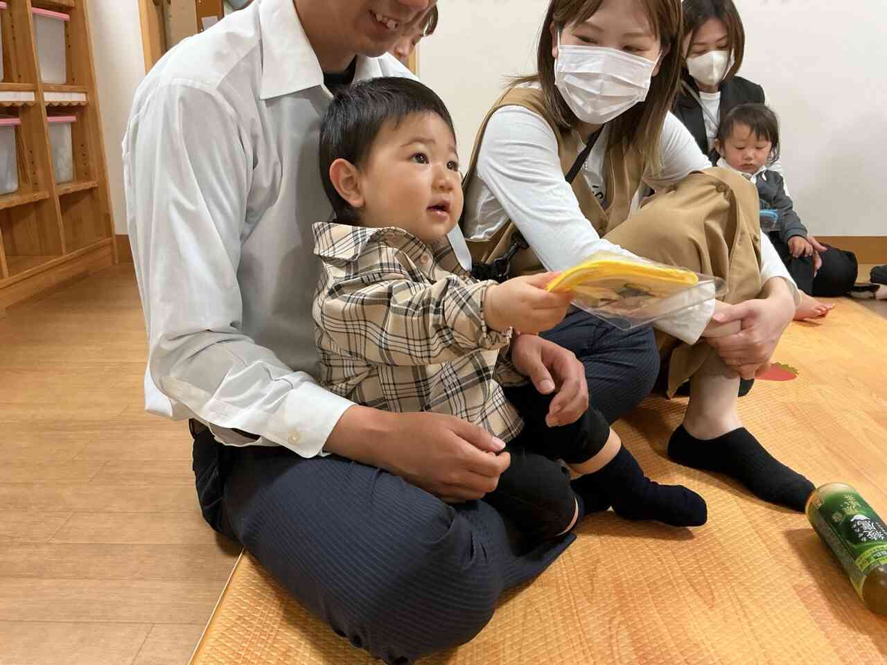 お父さんお母さんに見守られ、プレゼントをもらってにっこり笑顔