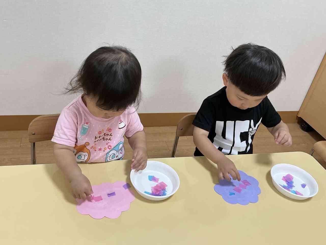 真剣に（ちぎった）花びらを貼っています。