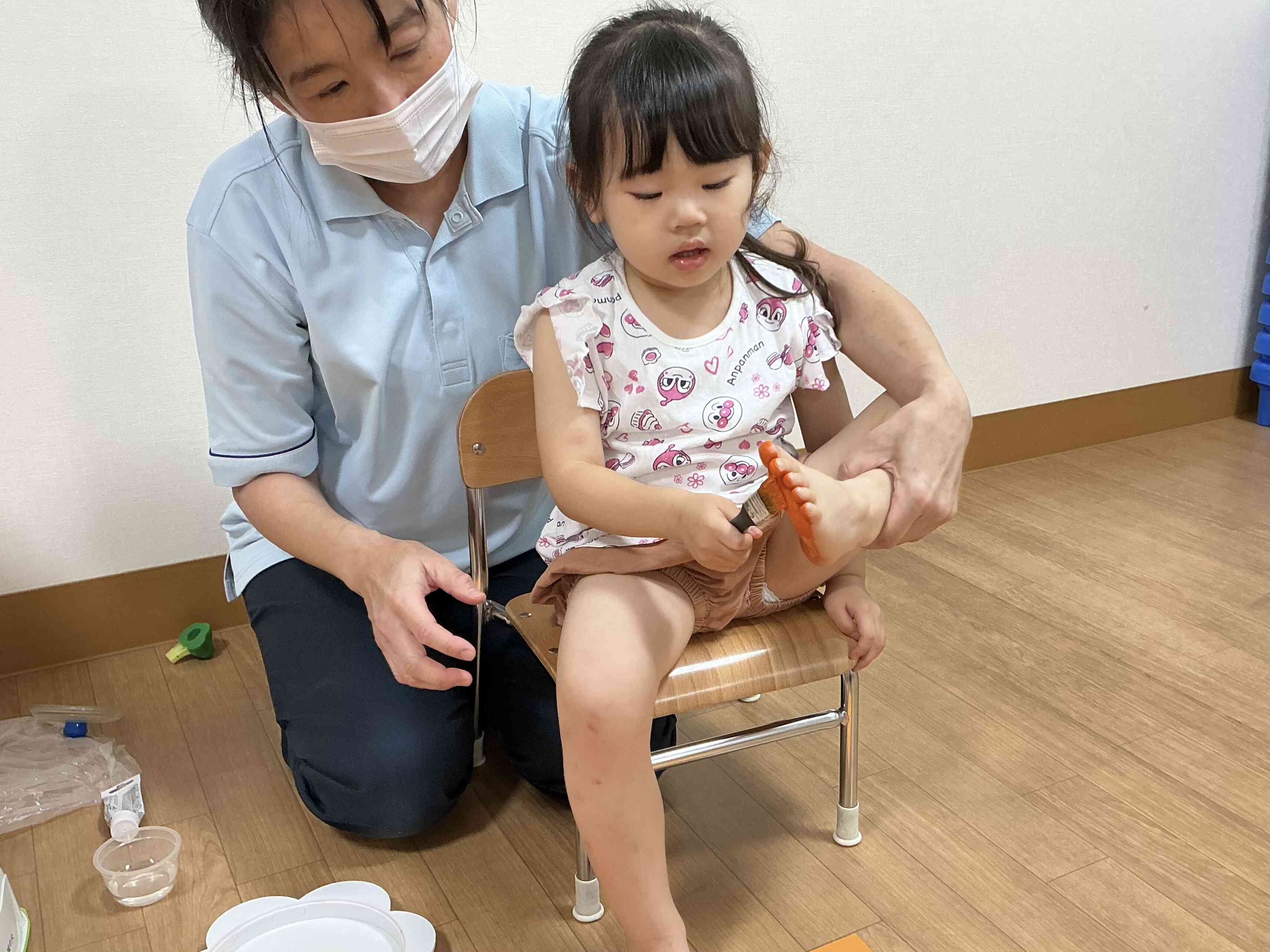 くすぐったいけど、真剣な表情で、塗っています