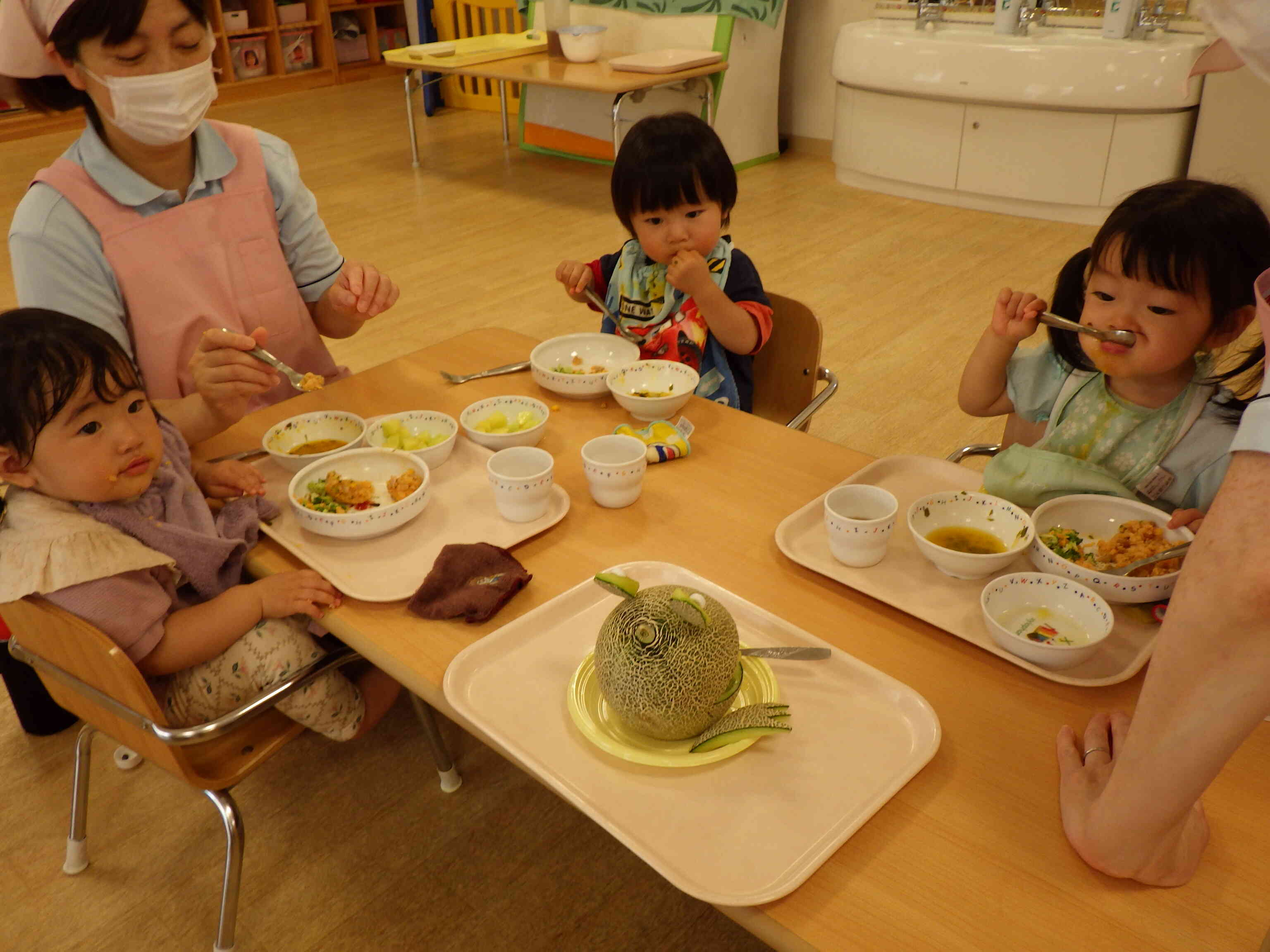 カエルさんのかわいい口から、おかわりメロンをもらいました。上手に食べるところ、見ていてね。