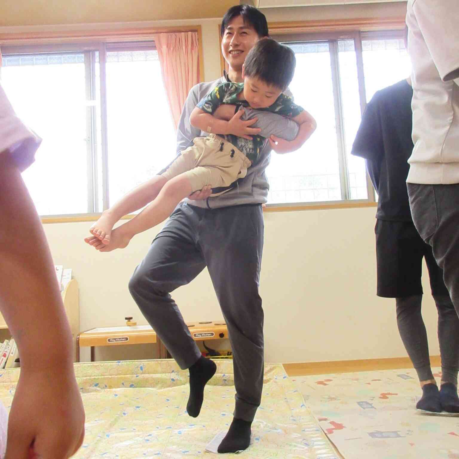 新聞紙の島が小さくなたら、抱っこしてもらって、最後は片足立ち！