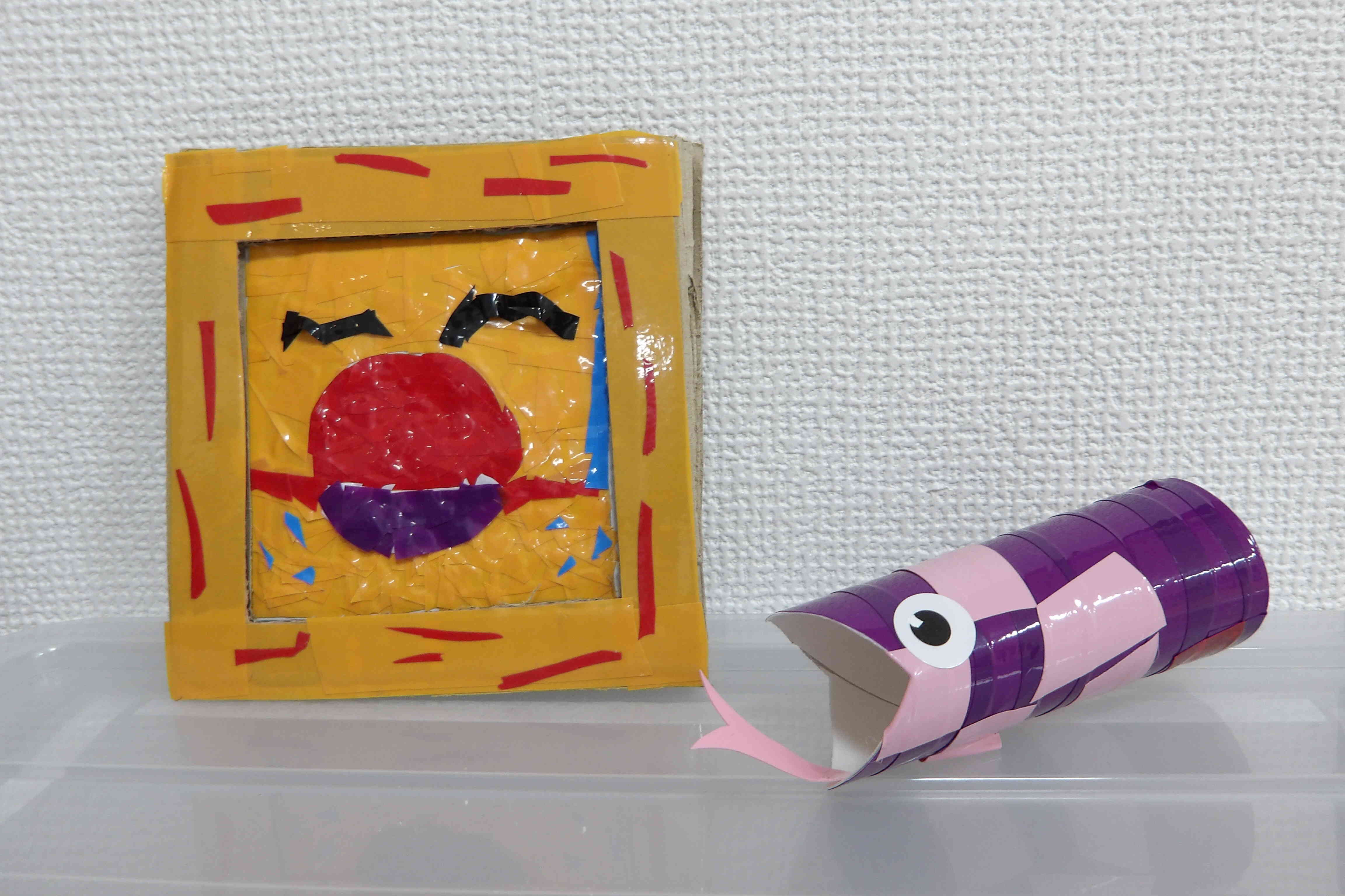 ビニールテープで太陽をえがいた作品と、模様付けしたヘビちゃん。色合いが素敵です