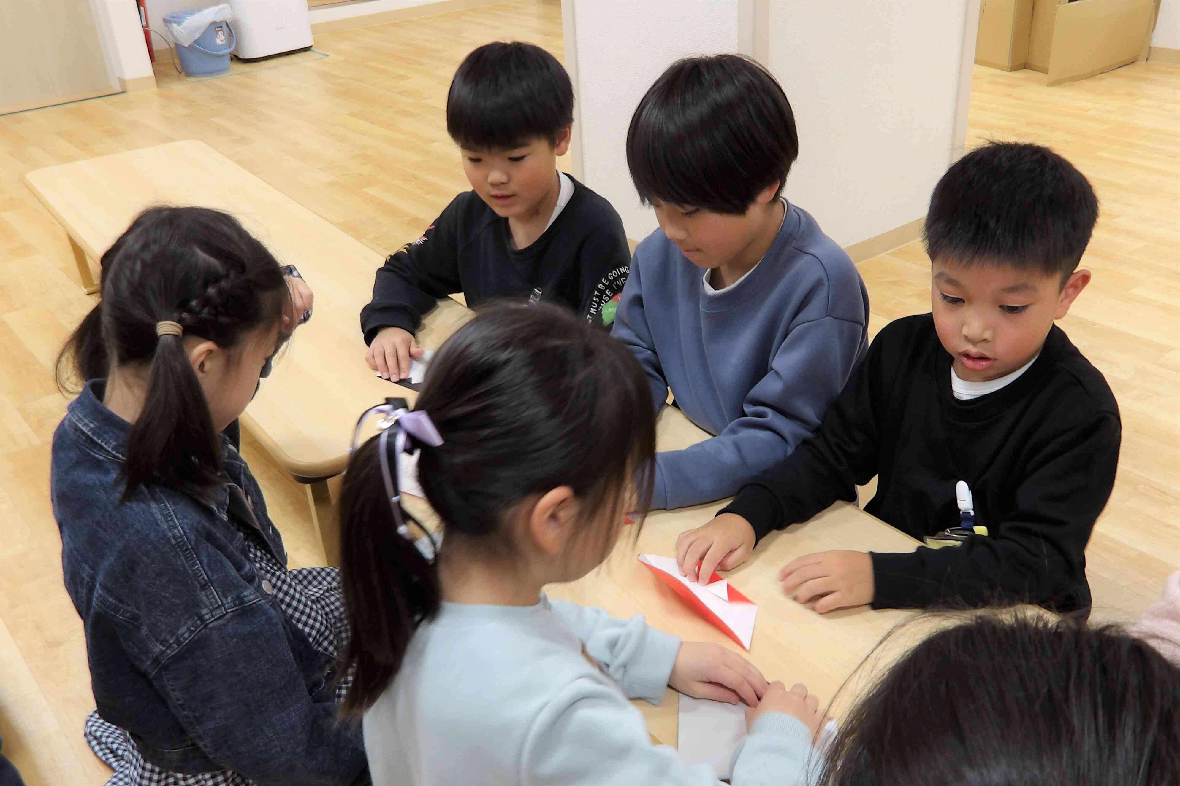 飾り用折り紙サンタの折り方を教わっています