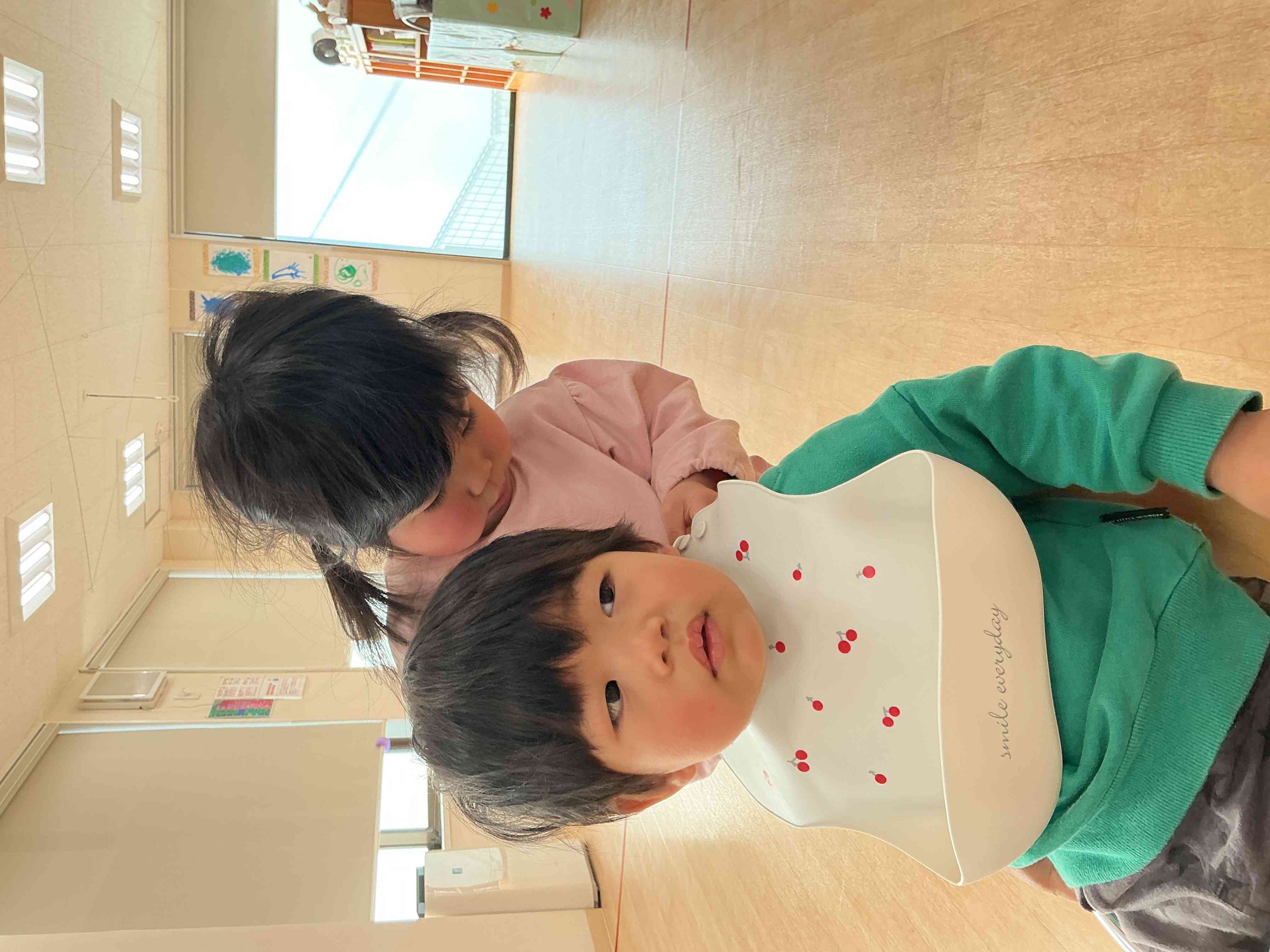 おやつの前にはお友達のエプロンをつけて