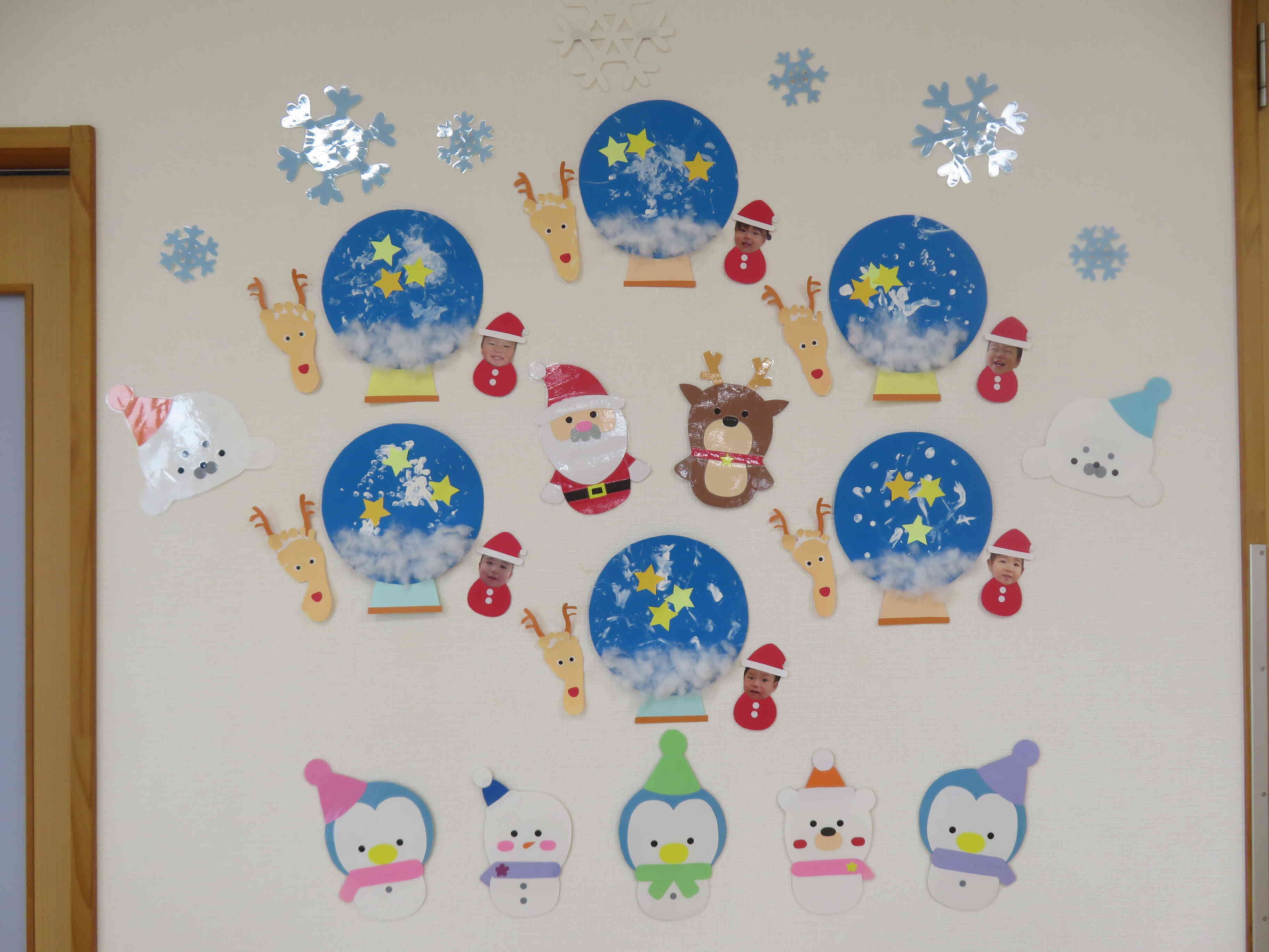 12月の壁面（ひよこぐみ）です。スノードームがキラキラ光っているみたいだね。足型で作ったトナカイさんがとってもキュートです♡