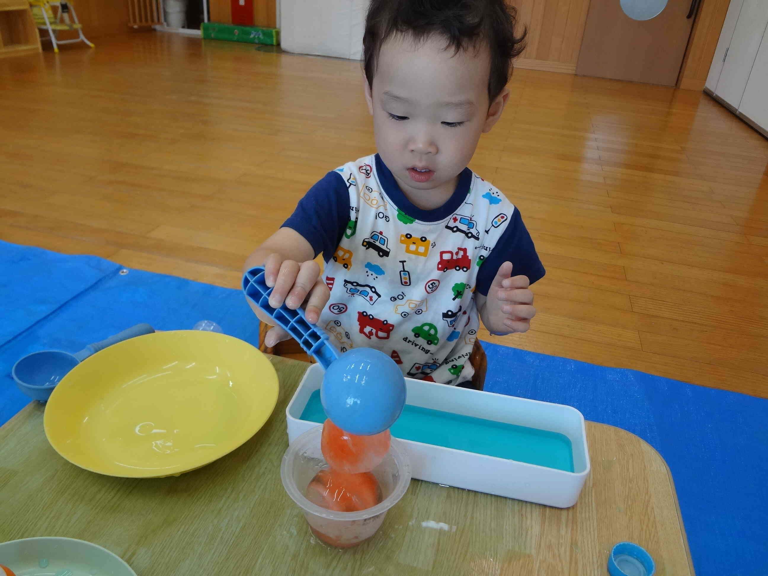 Kくんはまんまるい氷がぴったりはいるお玉を使って上手に容器に移していました。