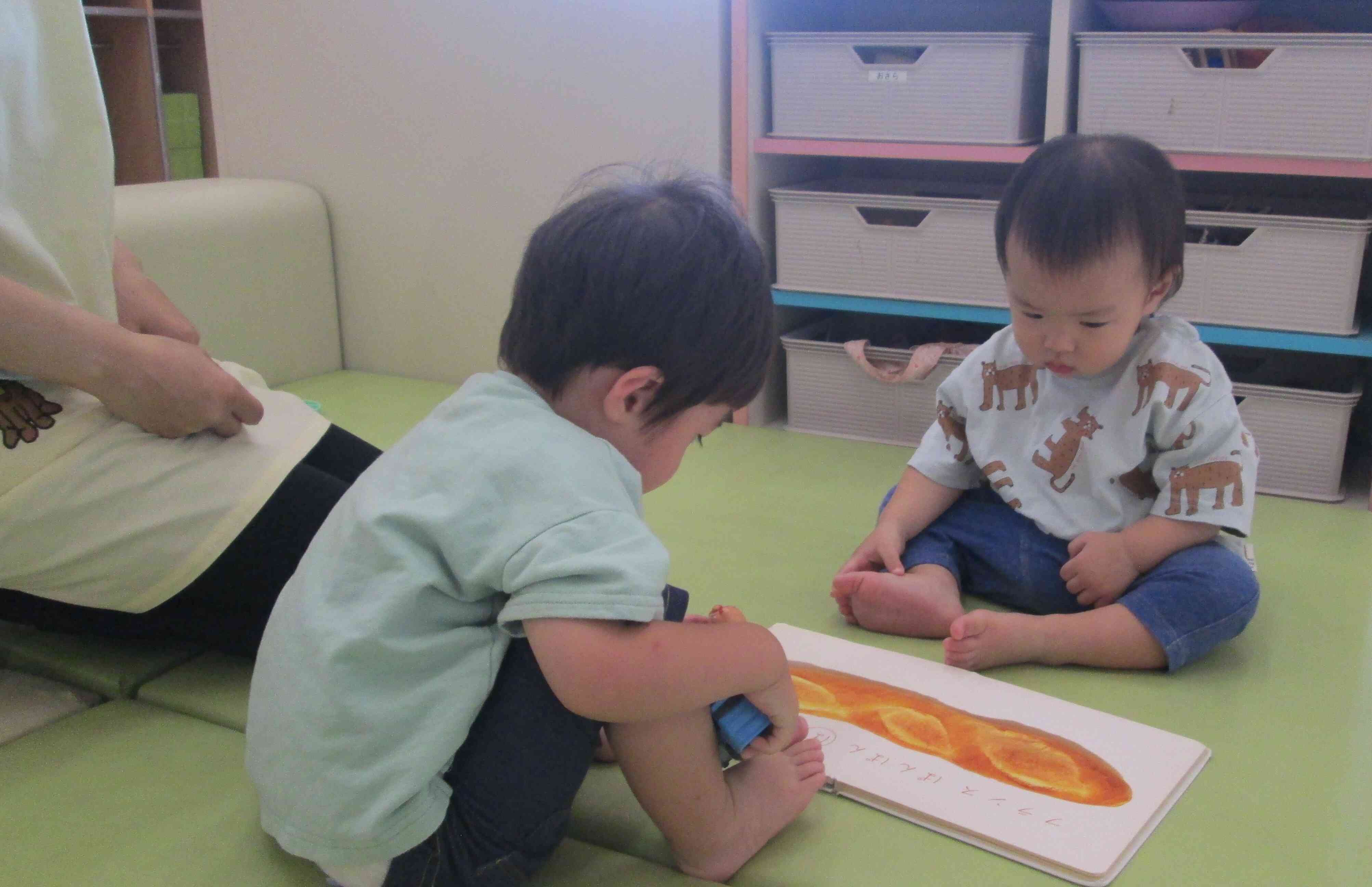 新しいお友だちです。大きいお友だちと一緒に絵本をみています！