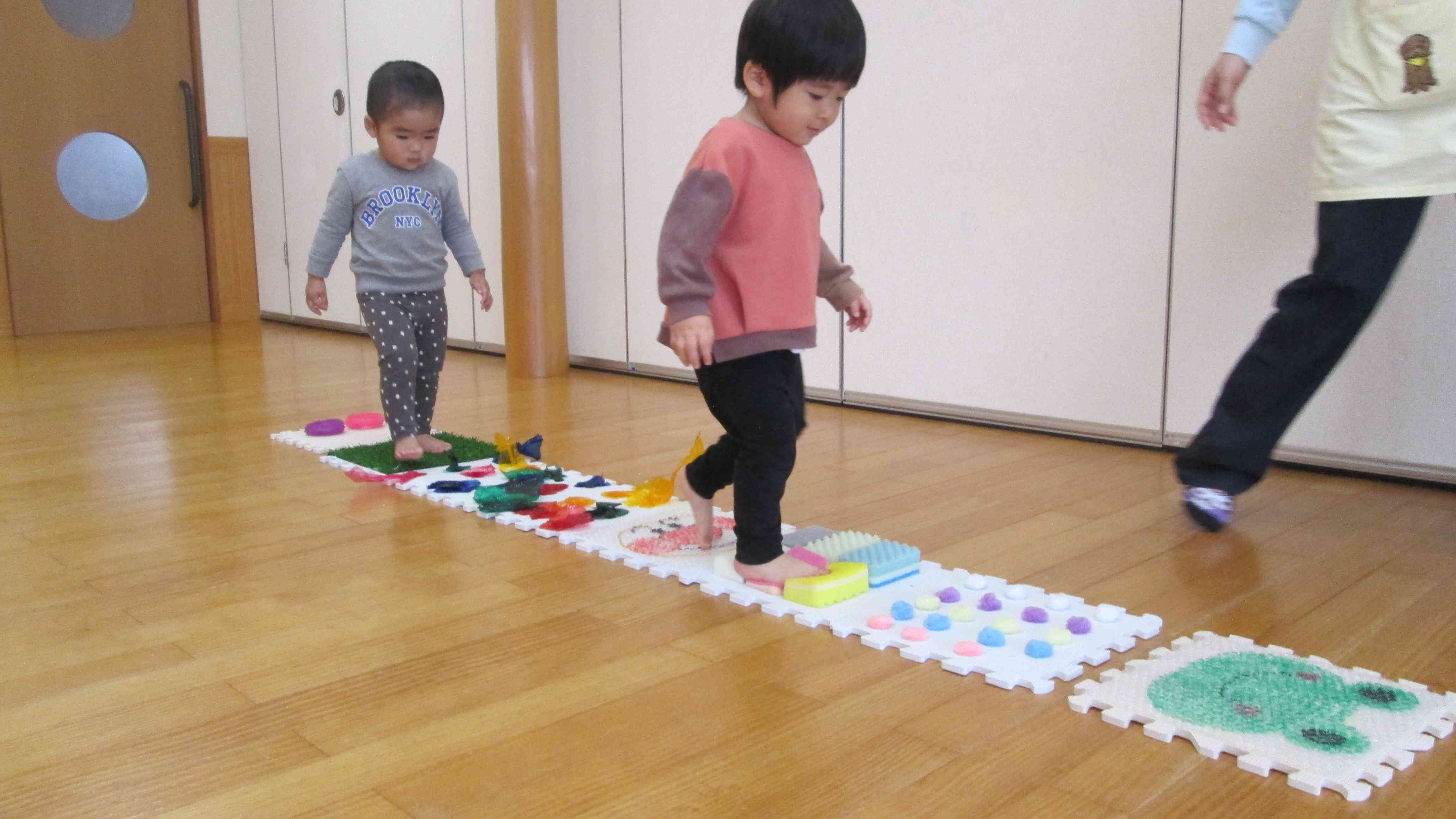 センサリーマットの感触を楽しんでいます。