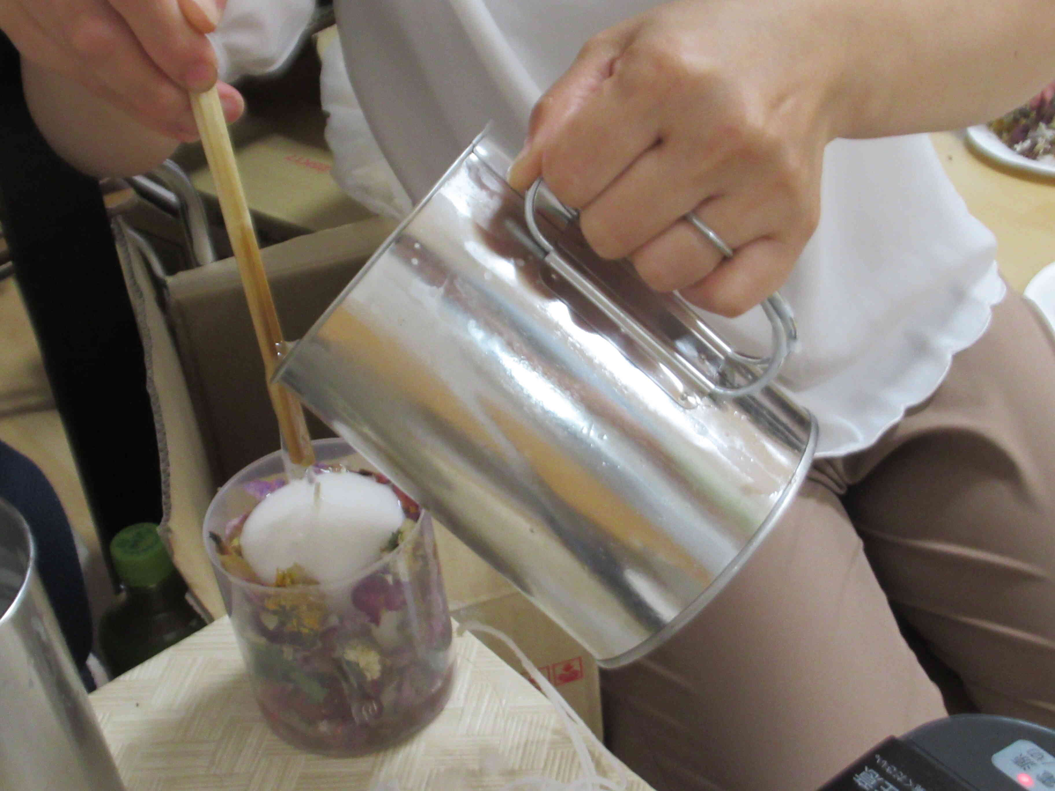 子どもたちがろうそくの周りに花を飾りつけたものに熱い蝋を流し込み、冷やして完成です